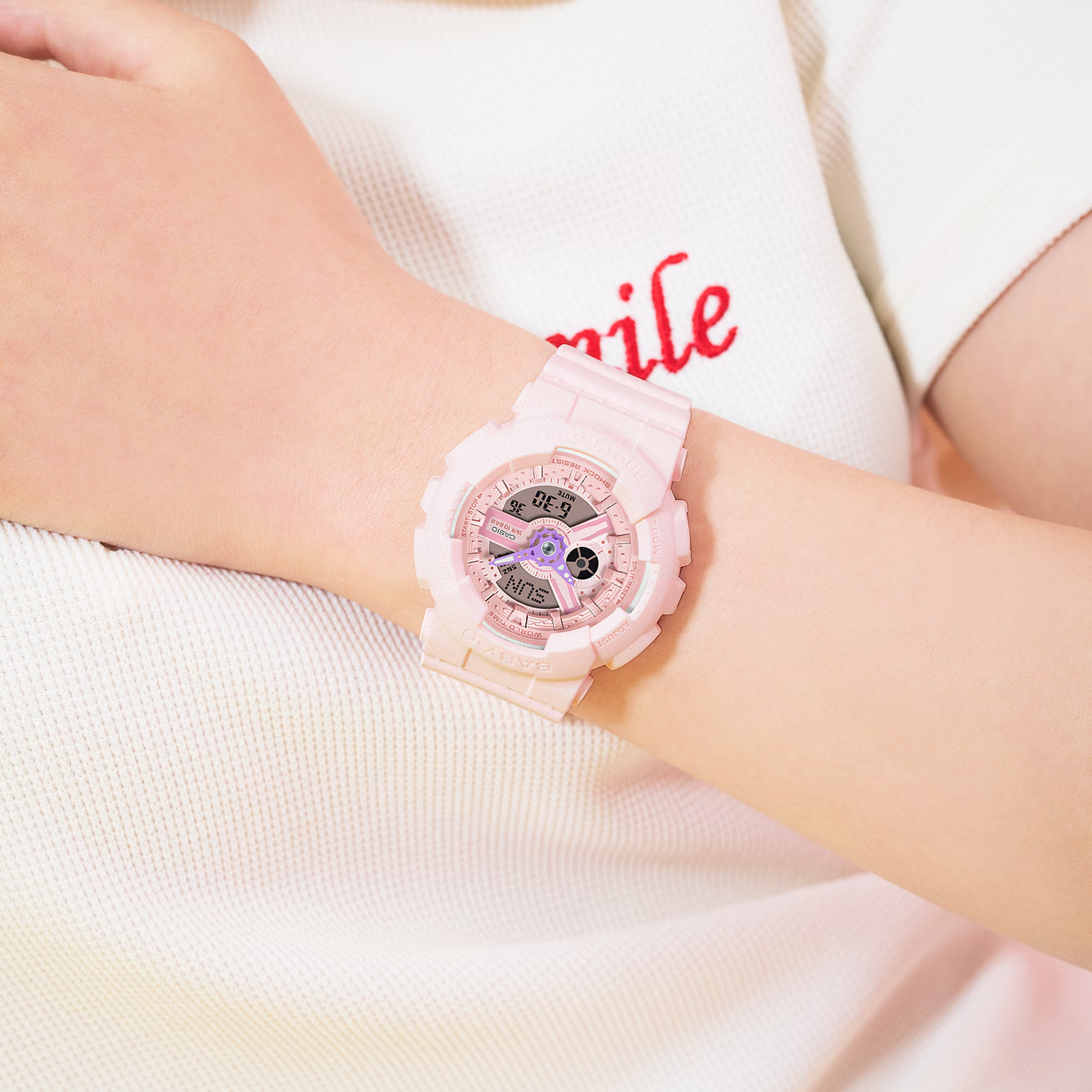 Pink digital watch on a wrist with a white background