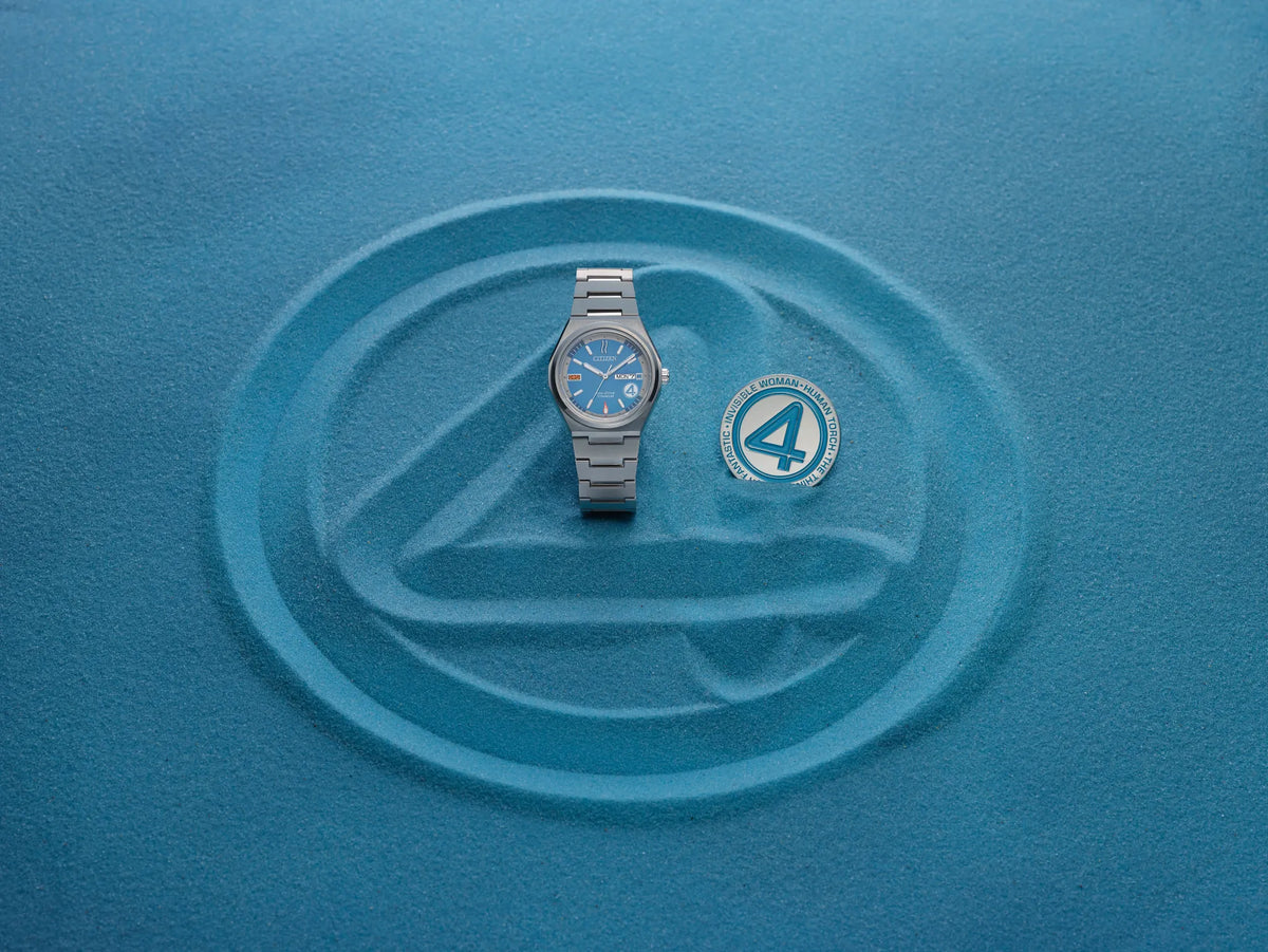 Citizen Fantastic 4 AW0131-66W displayed with collectible coin on a blue Fantastic 4 background, featuring the limited-edition blue dial Super Titanium Eco-Drive watch.