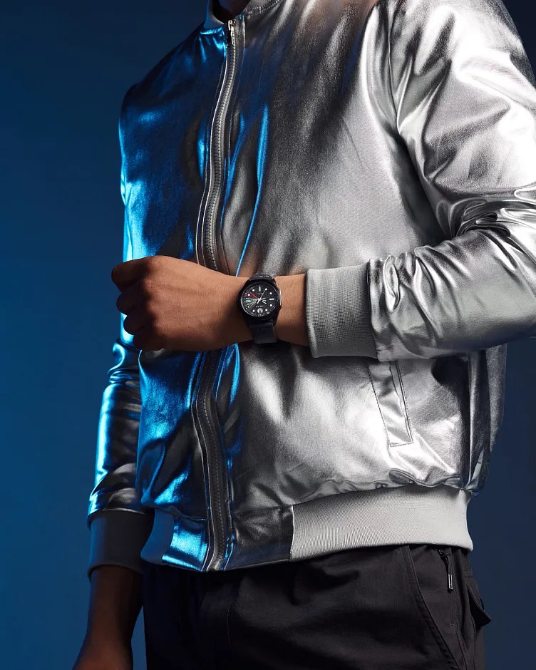 Person wearing a reflective silver jacket with a dark background