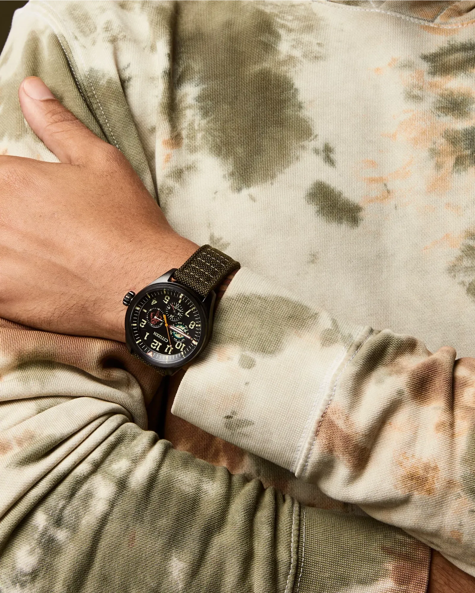 Hand wearing a watch with camouflage shirt