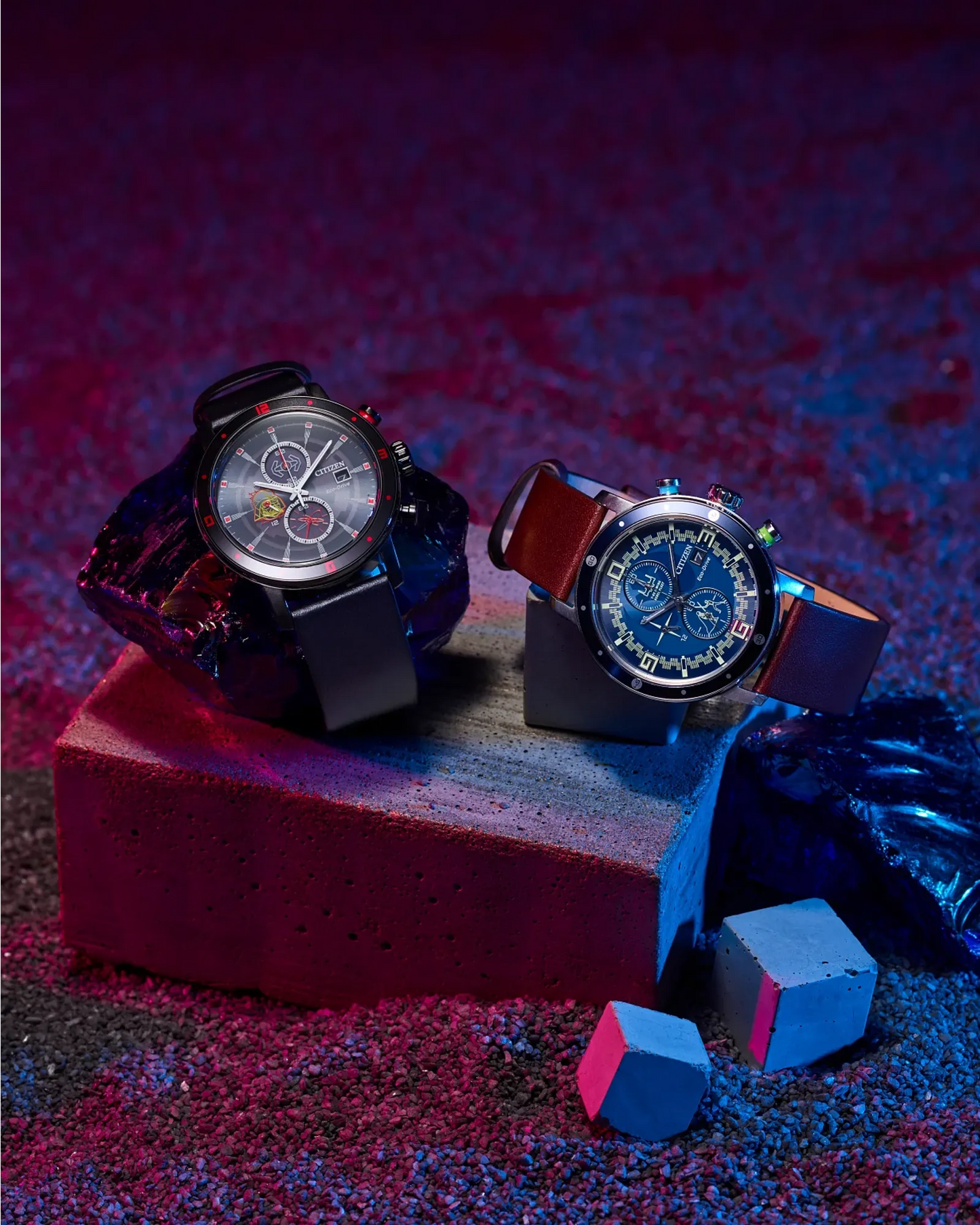 Two watches on a red and blue textured surface with a dark background
