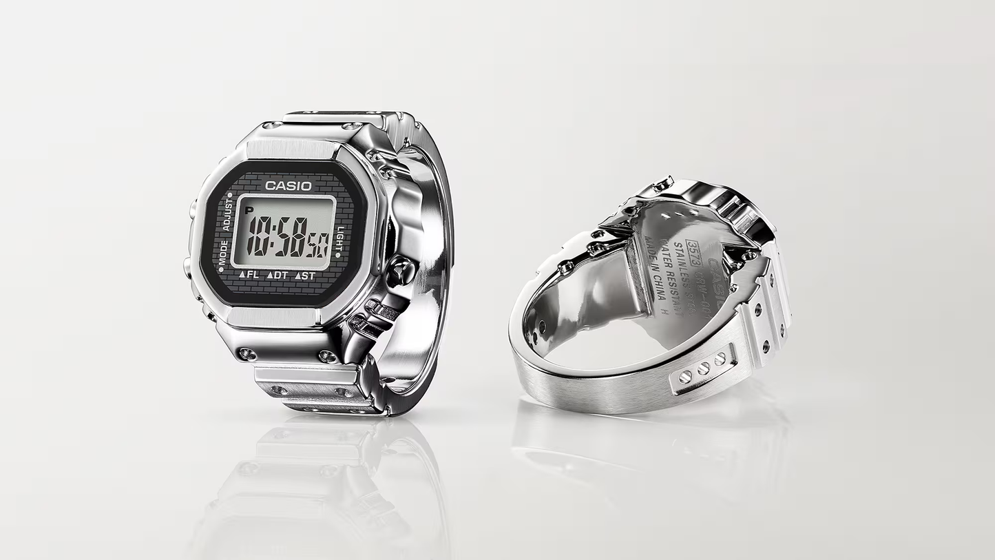 Casio digital watch and ring on a white background