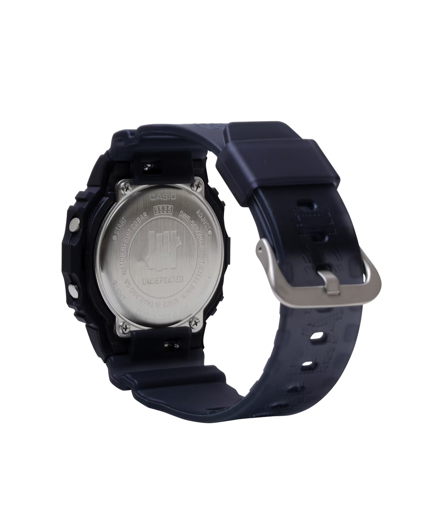Casio G-SHOCK DWE5600UD-1 UNDEFEATED collaboration model with matte black Carbon Core Guard case, semi-translucent resin band featuring UNDEFEATED logo, green LCD display, engraved caseback, and special packaging. Includes two interchangeable camouflage straps (tiger camo, storm camo). Features shock resistance, mineral glass, 200m water resistance, LED Super Illuminator backlight, stopwatch, countdown timer, alarms, flash alert, auto-calendar, and ±15 sec/month accuracy. Case size 48.9 × 43.8 × 13.7 mm, we