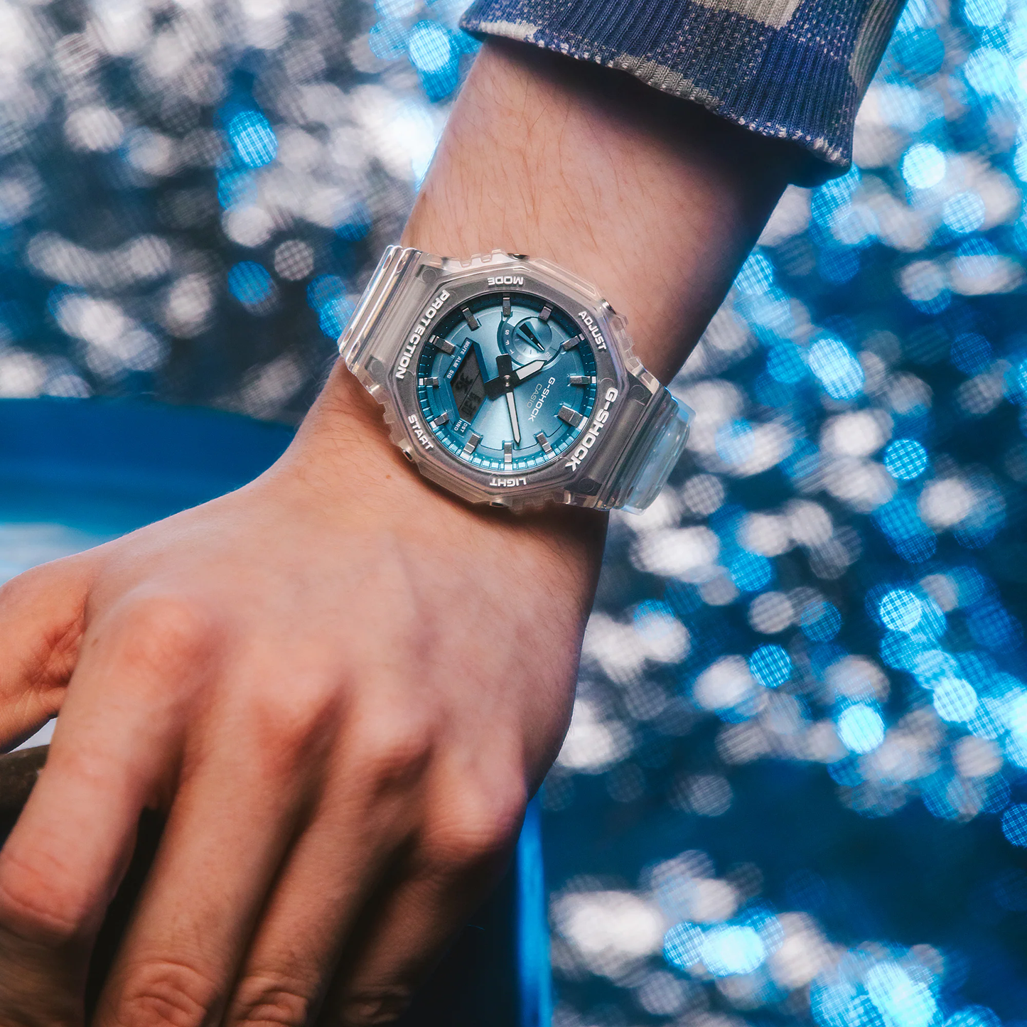 Casio G-Shock GA2100BM-7A2 watch with translucent resin case and band, metallic sky-blue dial, octagonal bezel, and Carbon Core Guard construction