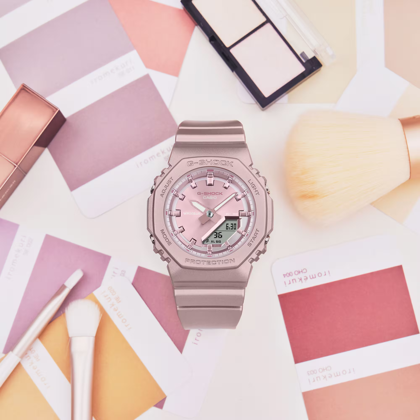 Pink watch on a colorful geometric patterned surface