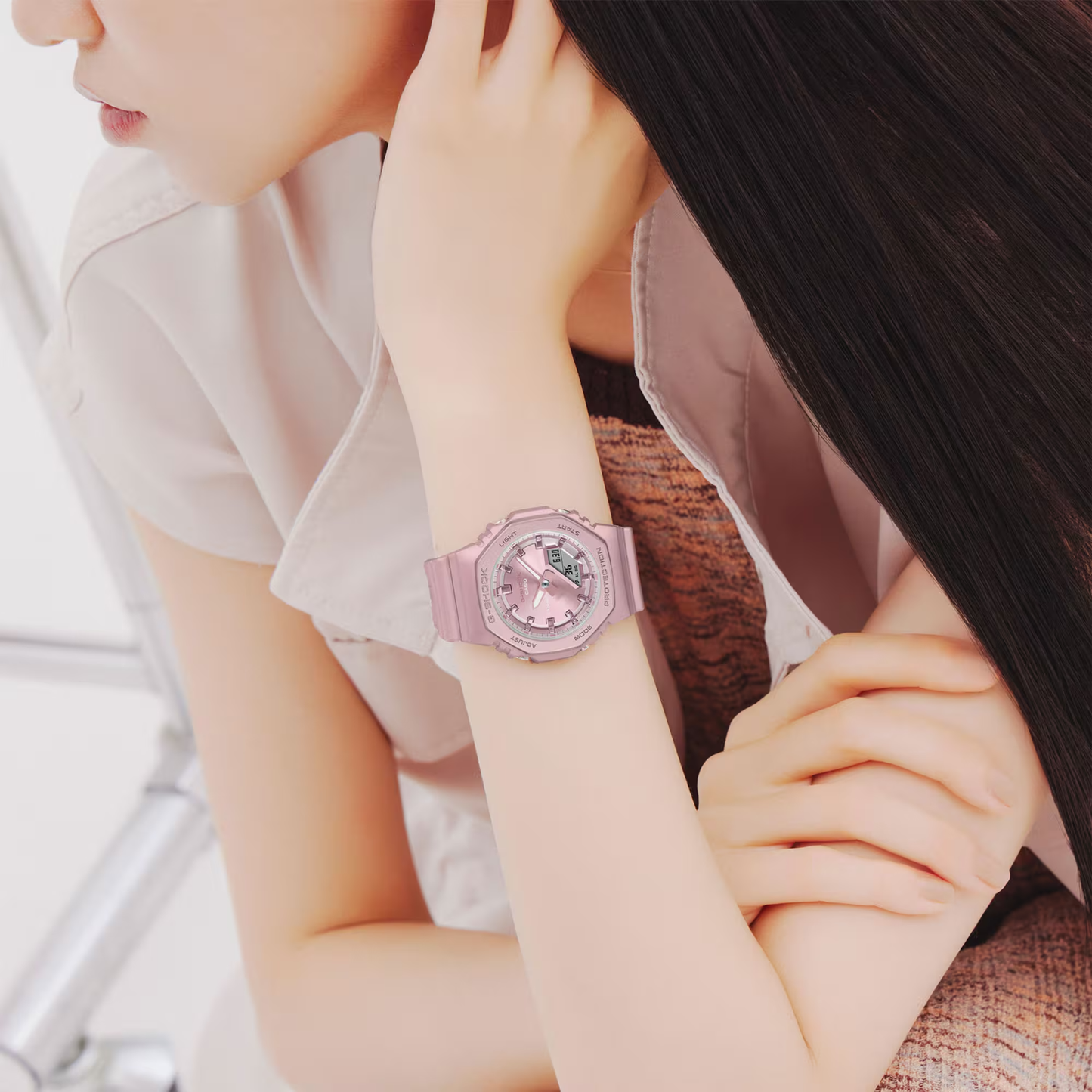 Person wearing a pink watch with a white background