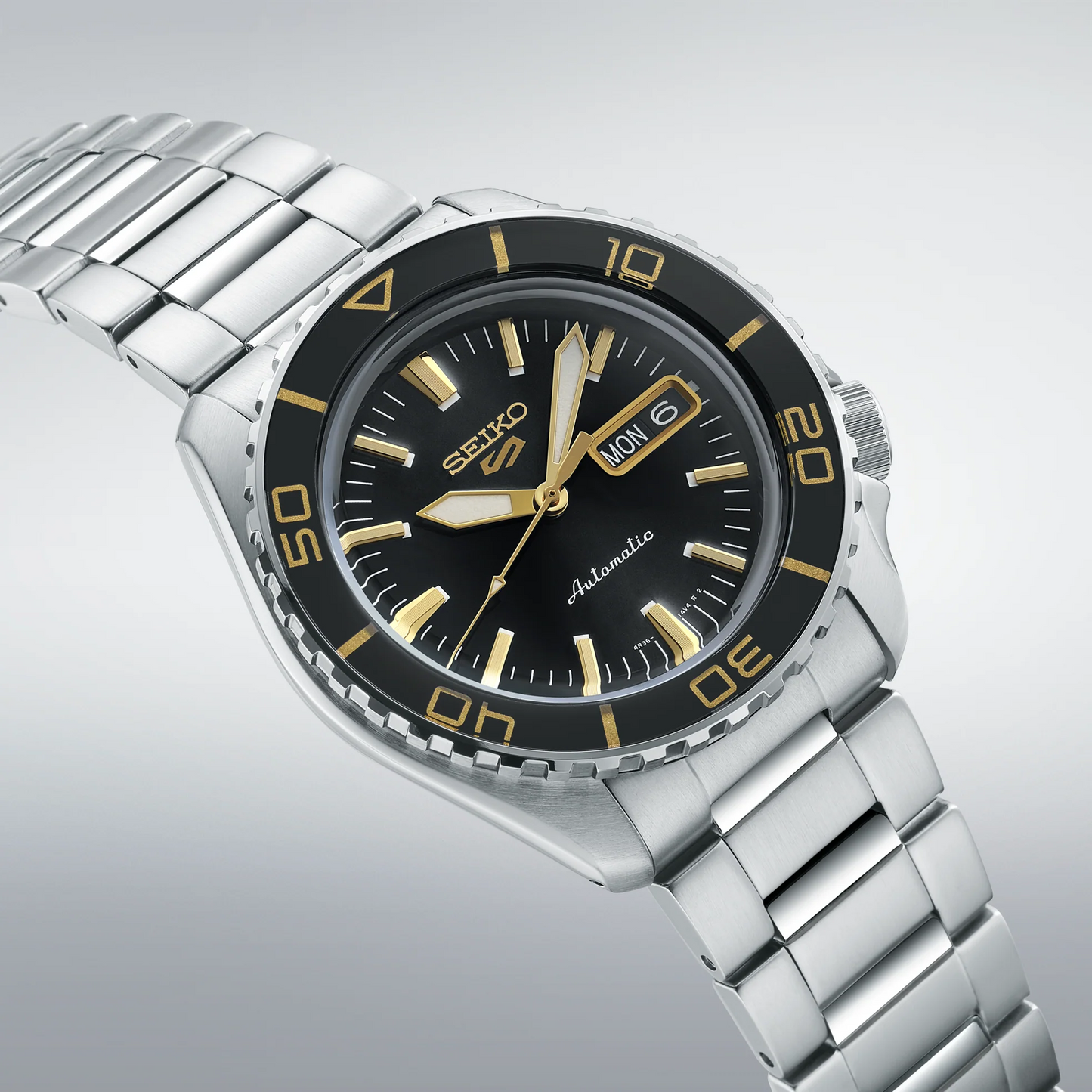 Seiko 5 Sports SRPK99 – black dial with gold accents, rotating bezel, stainless steel case and bracelet, automatic 4R36 movement, and see-through caseback with 100m water resistance
