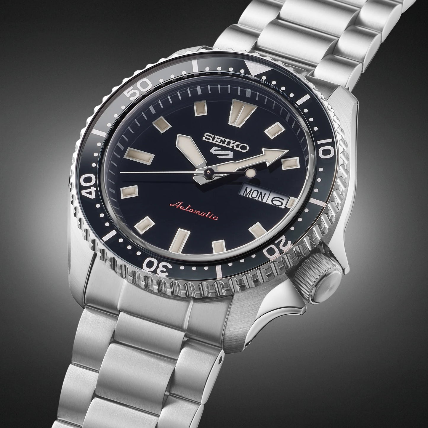 SEIKO 5 Sports SRPL85 SKX Sports Style – black dial and bezel, stainless steel bracelet, automatic movement, and 100m water resistance.