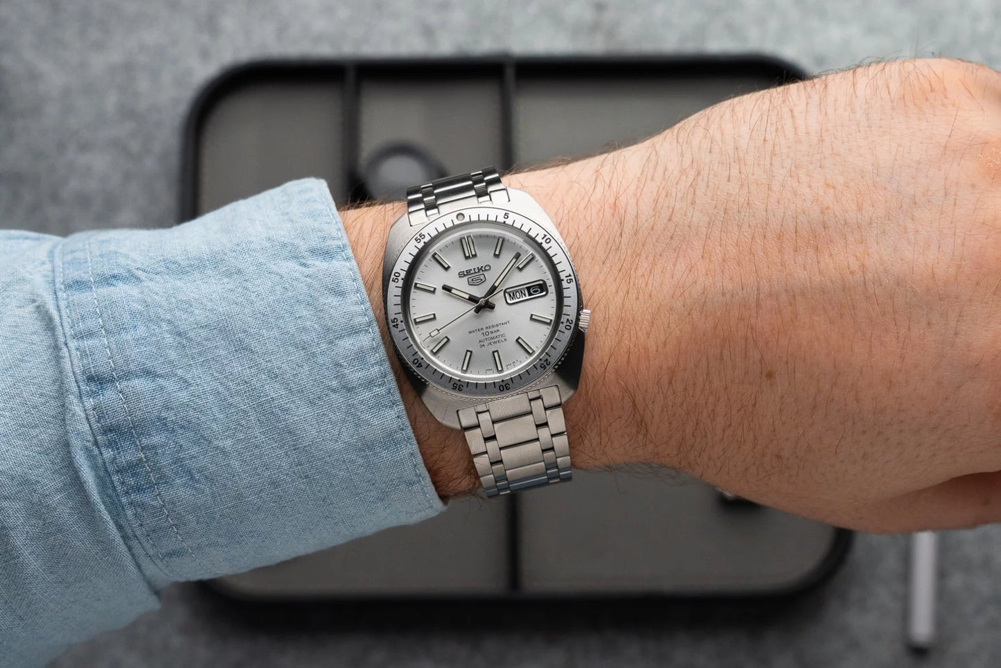 Seiko 5 Sports SRPL91 – limited-edition SKX-inspired automatic watch with silver sunray dial, rotating bezel, curved Hardlex crystal, and engraved caseback.