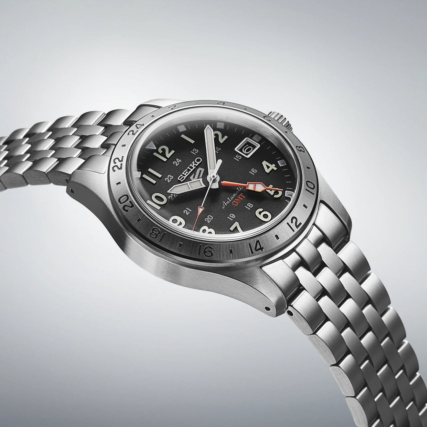 Silver Seiko watch with a black dial on a light gray background