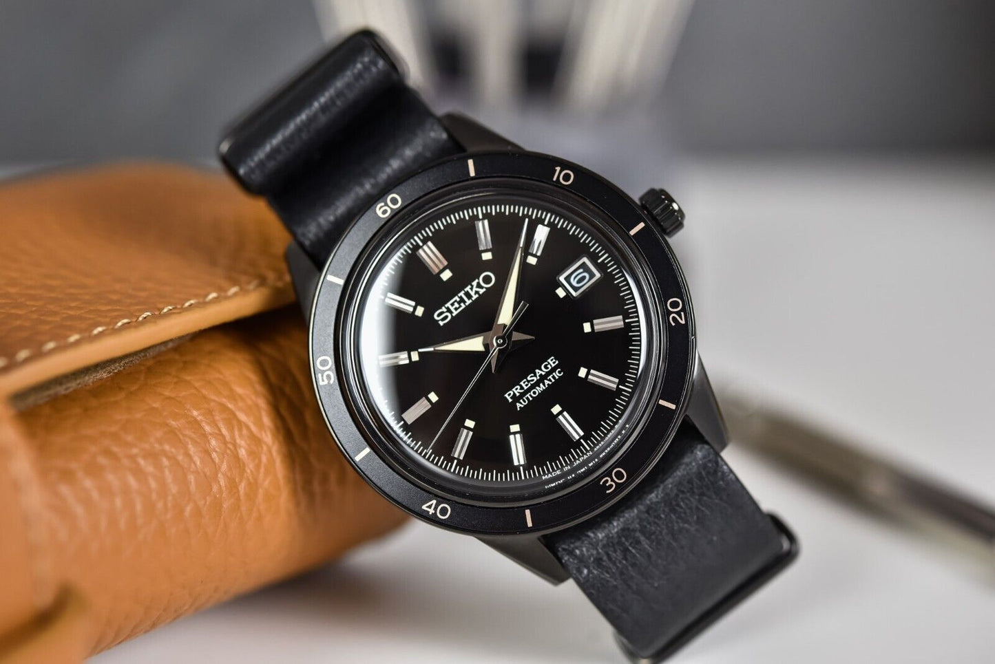 SEIKO SRPH95 from the Presage Style60’s Collection – black dial and bezel, beige LumiBrite hands, black deerskin strap, black hard-coated stainless steel case, automatic movement, and 50m water resistance.