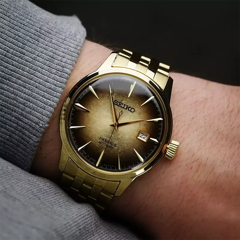 SEIKO Presage Cocktail Time U.S. Special Creation – gold-tone case and bracelet, brown and gold dial inspired by the Half and Half cocktail, automatic movement, and 50m water resistance.
