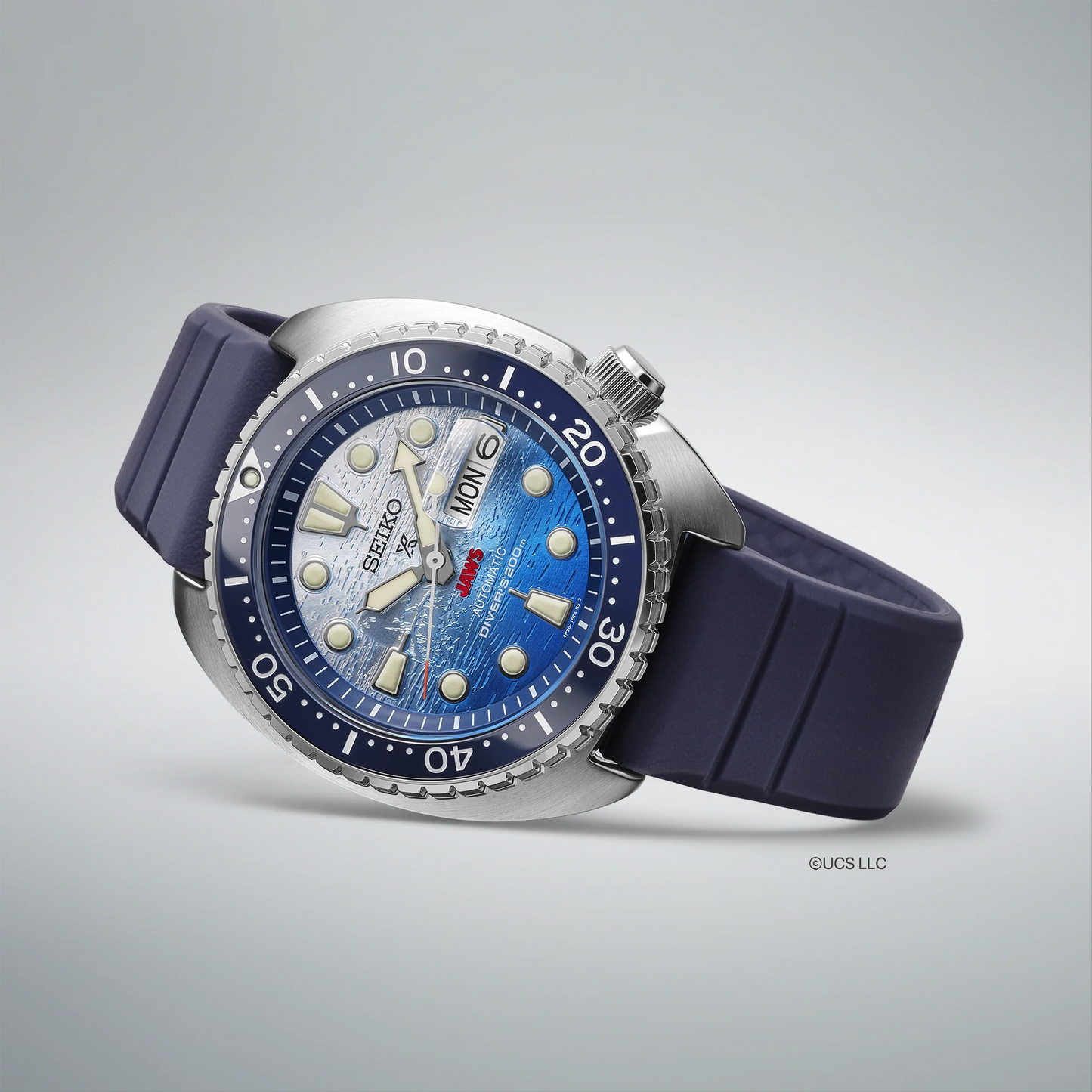 Seiko Prospex SRPL81 JAWS 50th Anniversary Limited Edition diver’s watch with 45 mm stainless steel case, blue ceramic unidirectional bezel, blue and white ombre dial with JAWS logo at 6 o’clock, LumiBrite hands and markers, sapphire crystal, Caliber 4R36 automatic movement, 200m ISO-certified water resistance, blue silicone strap, and engraved caseback featuring Orca boat and shark fin. Limited edition of 5,000 pieces.