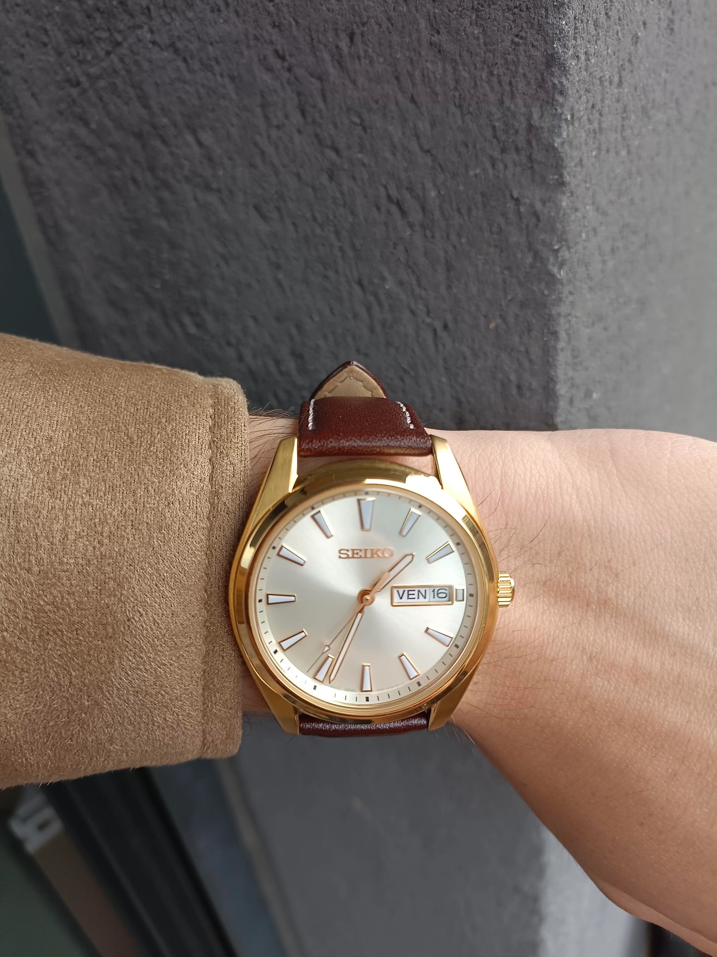Seiko Essentials SUR450 – elegant gold-tone men’s quartz watch with champagne dial, sapphire crystal, day/date window, and brown leather strap