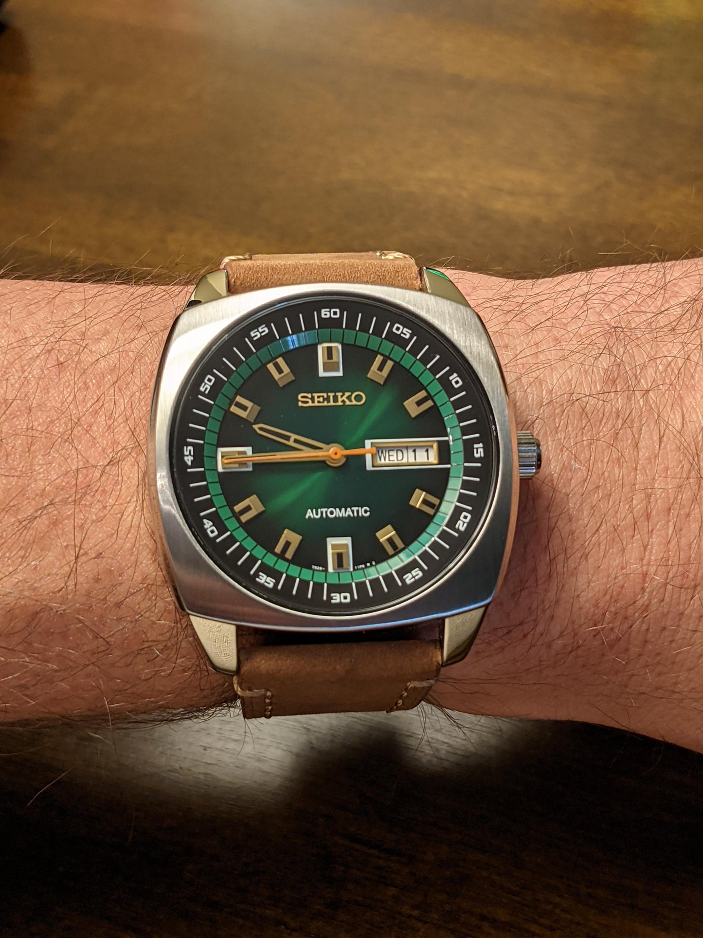 Seiko SNKM97 – bold retro-style automatic watch from the Recraft Series with green sunray dial, gold-tone accents, cushion-shaped stainless steel case, and see-through caseback.