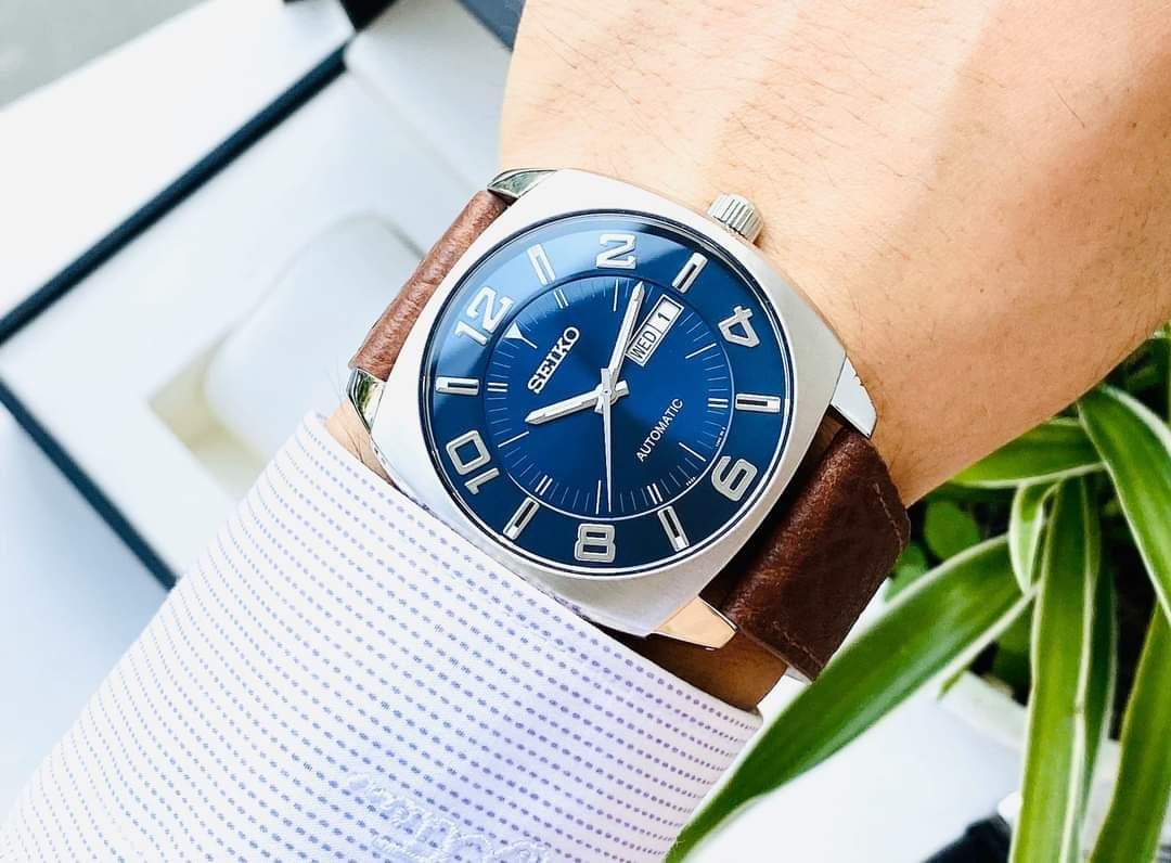 Seiko SNKN37 Recraft – bold blue dial automatic watch with retro cushion-shaped case, brown leather strap, luminous markers, see-through caseback, and 41-hour power reserve.