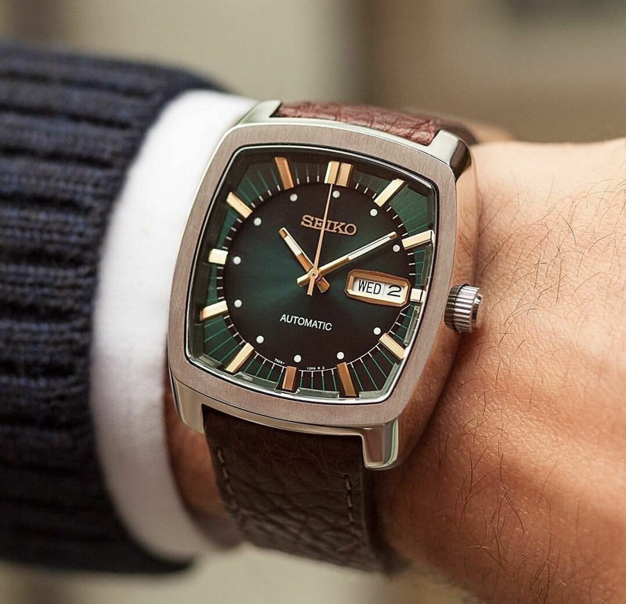 Seiko SNKP27 Recraft – retro cushion-shaped automatic watch with teal green dial, gold-tone markers, brown leather strap, see-through caseback, and 41-hour power reserve.