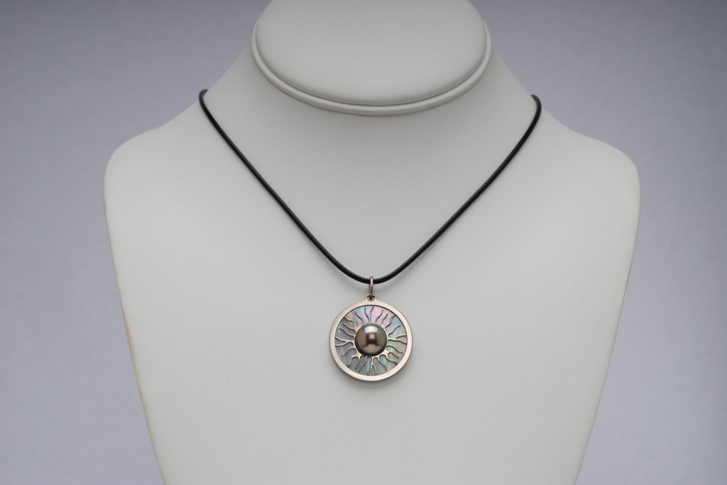 Titanium black freshwater pearl necklace with mother-of-pearl inlay, 10-11mm dyed black button-shaped pearl, exclusive sun-inspired design by Miseki Jewelry, adjustable waxed cotton cord, stainless steel lobster clasp