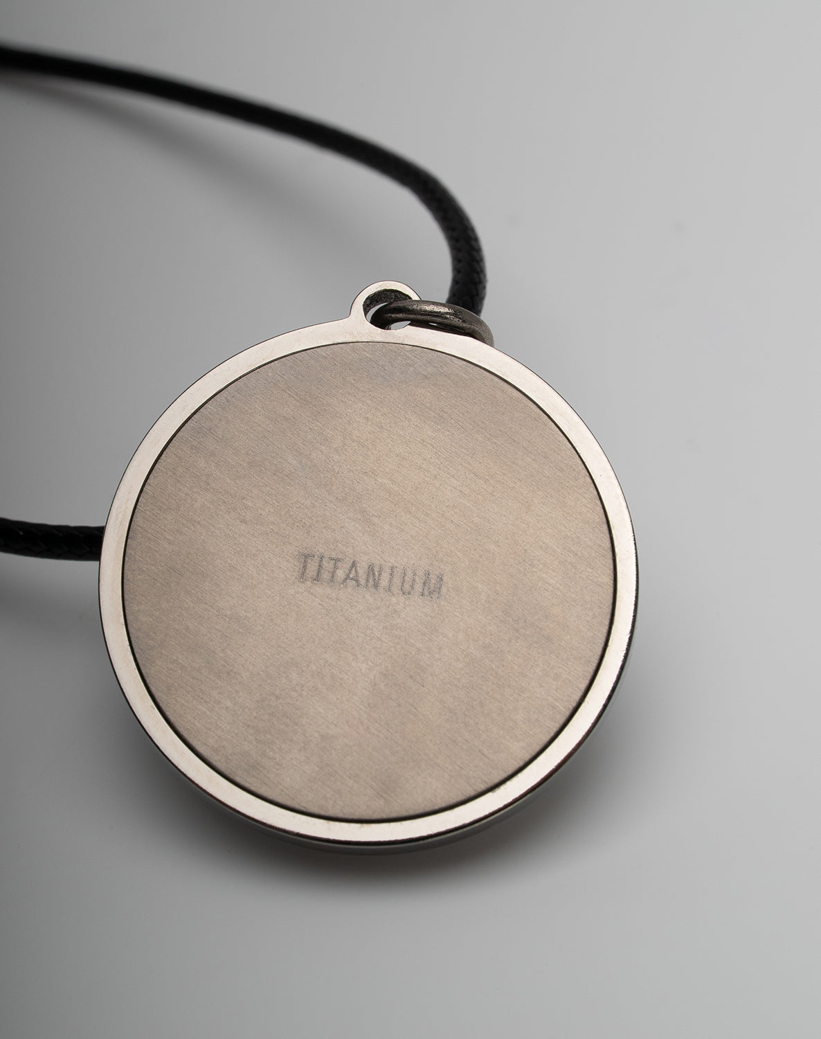Titanium black freshwater pearl necklace with mother-of-pearl inlay, 10-11mm dyed black button-shaped pearl, exclusive sun-inspired design by Miseki Jewelry, adjustable waxed cotton cord, stainless steel lobster clasp
