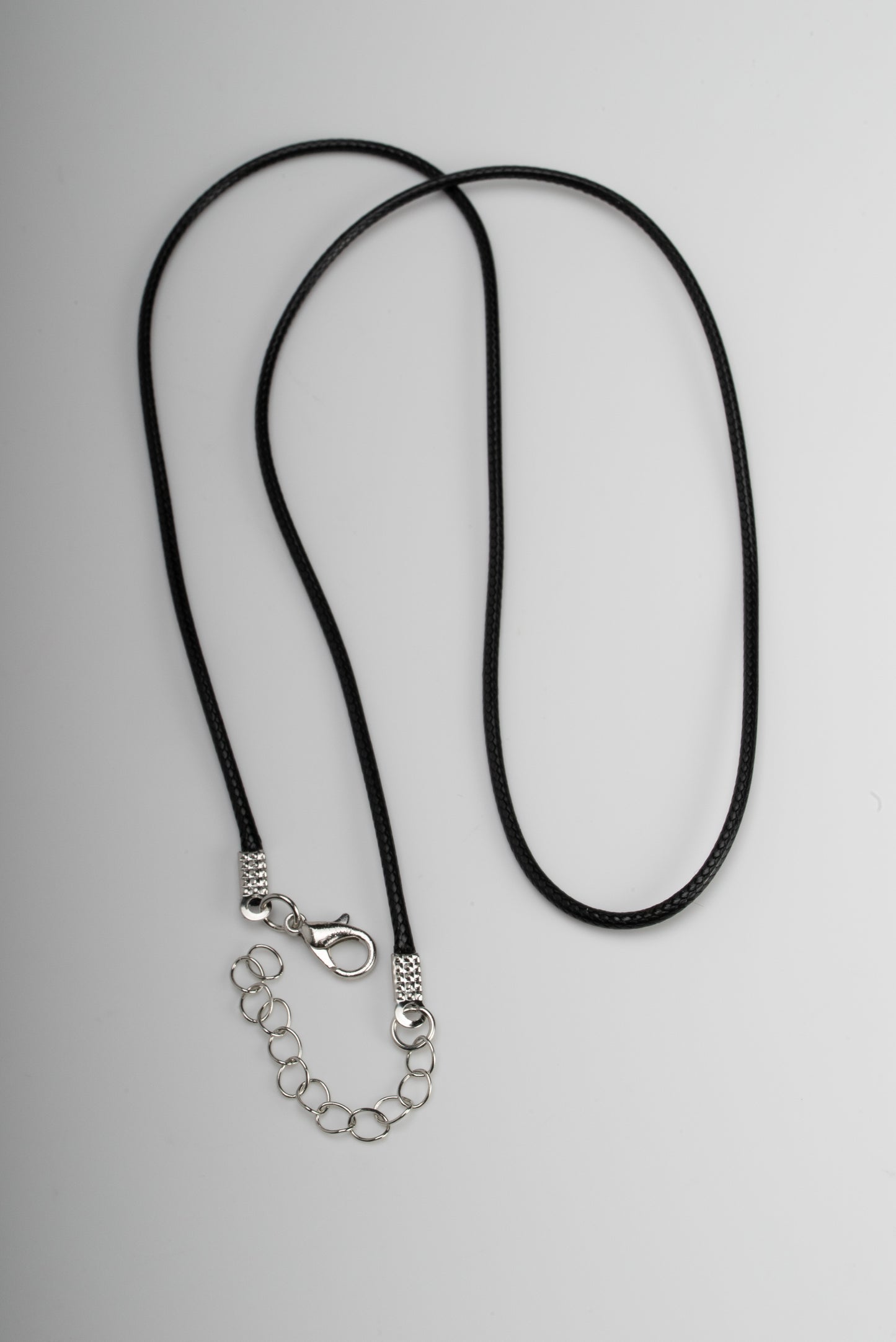 Titanium black freshwater pearl necklace with mother-of-pearl inlay, 10-11mm dyed black button-shaped pearl, exclusive sun-inspired design by Miseki Jewelry, adjustable waxed cotton cord, stainless steel lobster clasp
