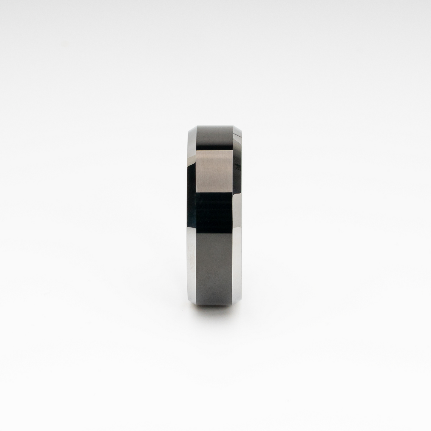 Polished black tungsten carbide ring with bold beveled edges. Minimalist, scratch-resistant, and comfort fit—perfect as a men’s wedding band, promise ring, or modern unisex fashion accessory.
