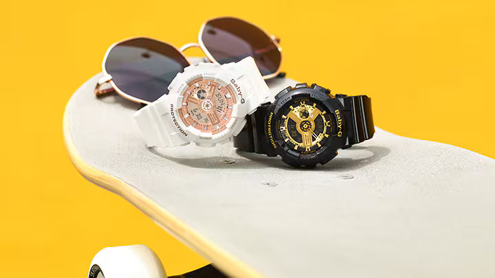 Two watches on a skateboard with a yellow background