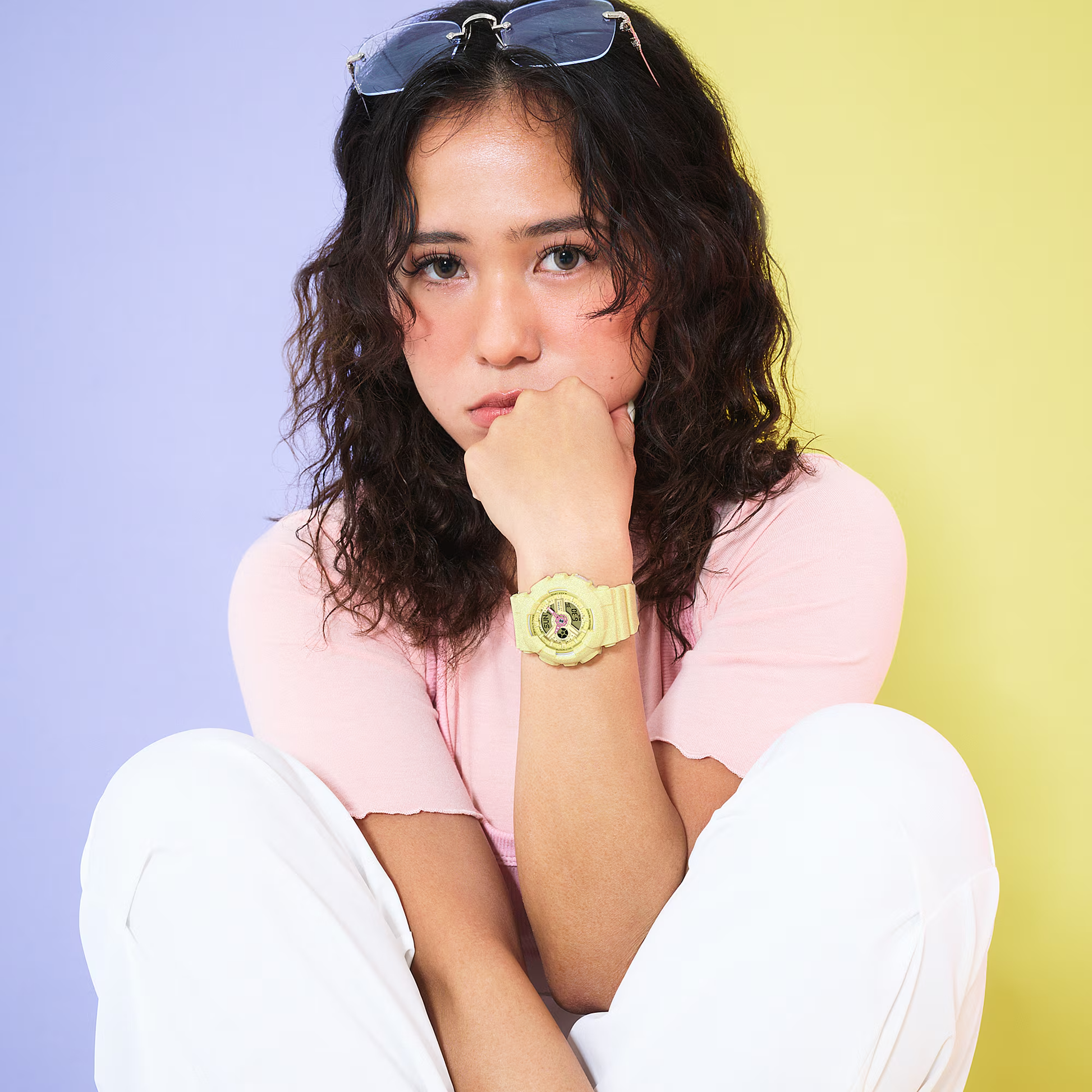 Woman wearing a pink shirt and white pants with a colorful background