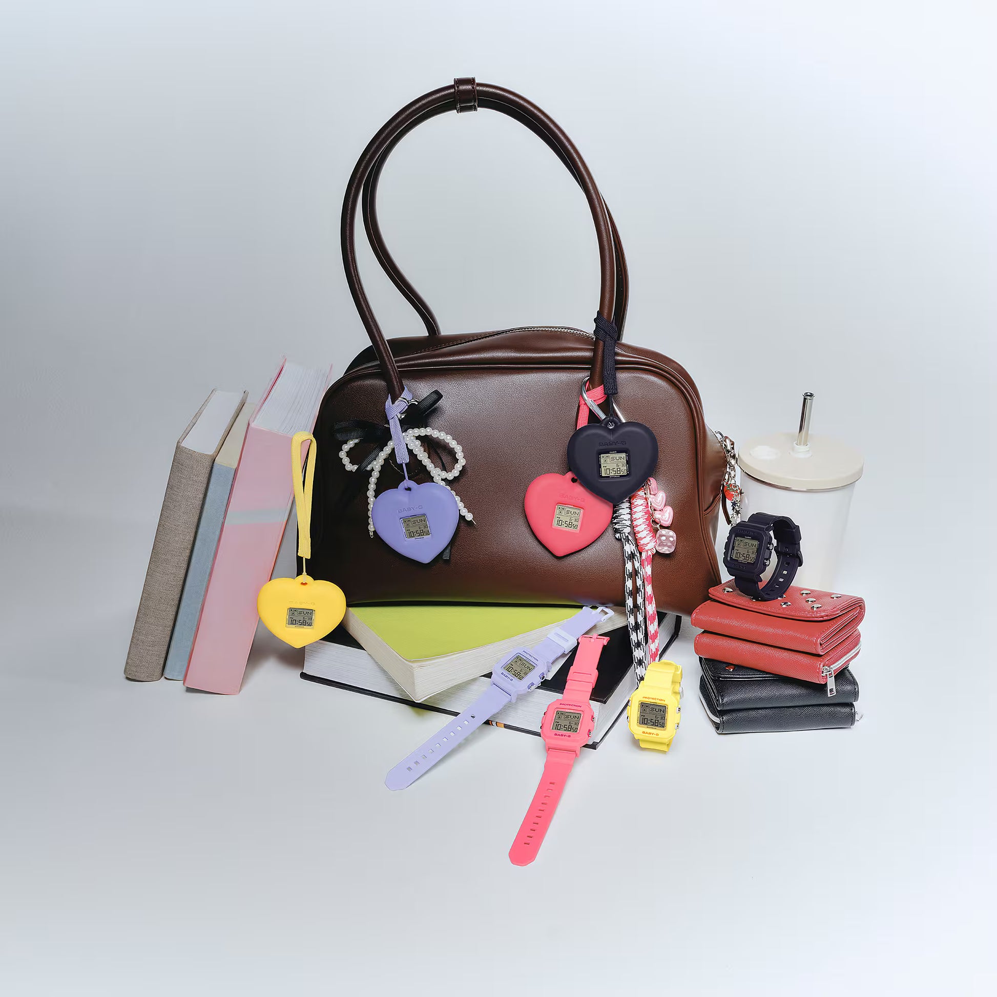 Brown handbag with colorful keychains and watches on a white background