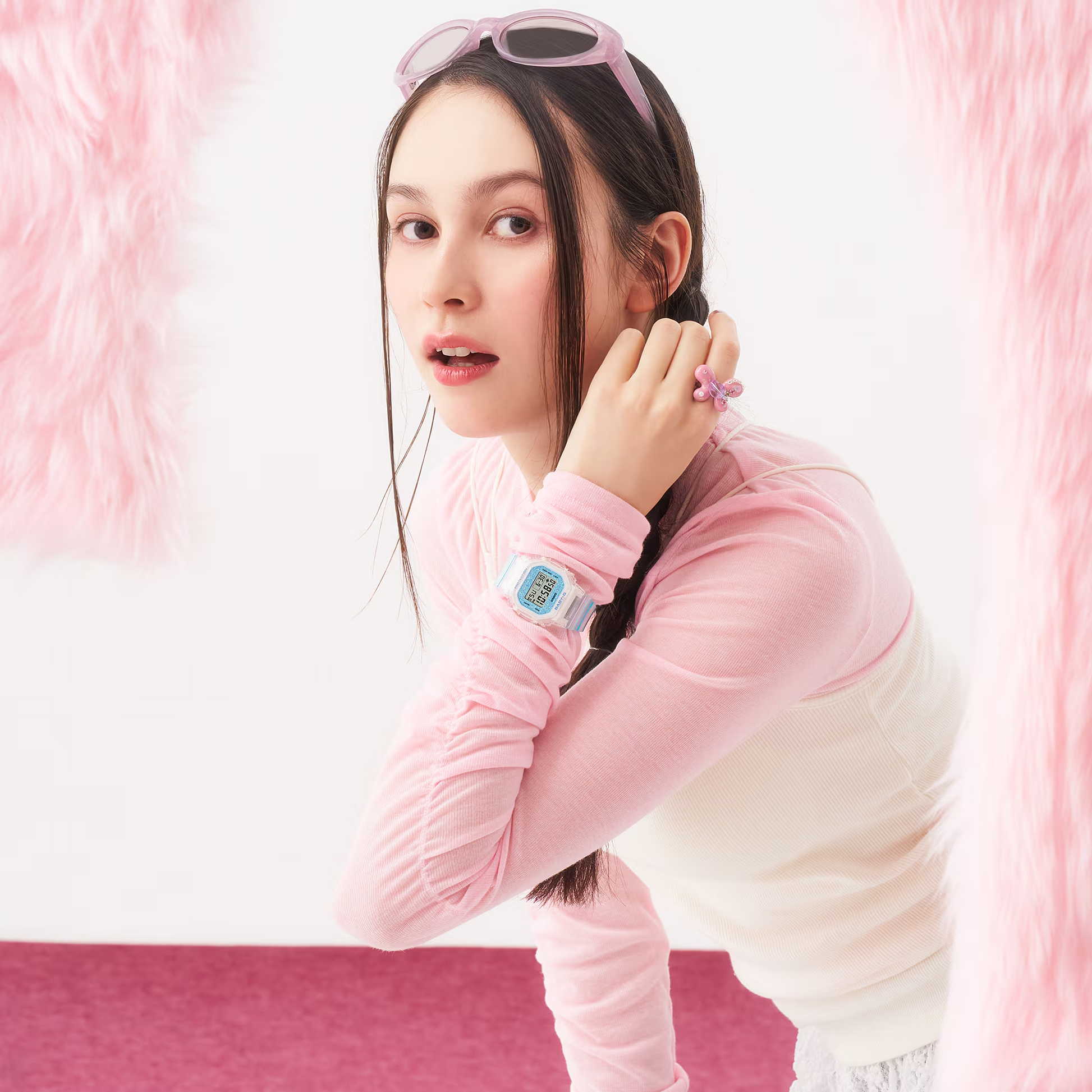 Woman posing against a pink and white background