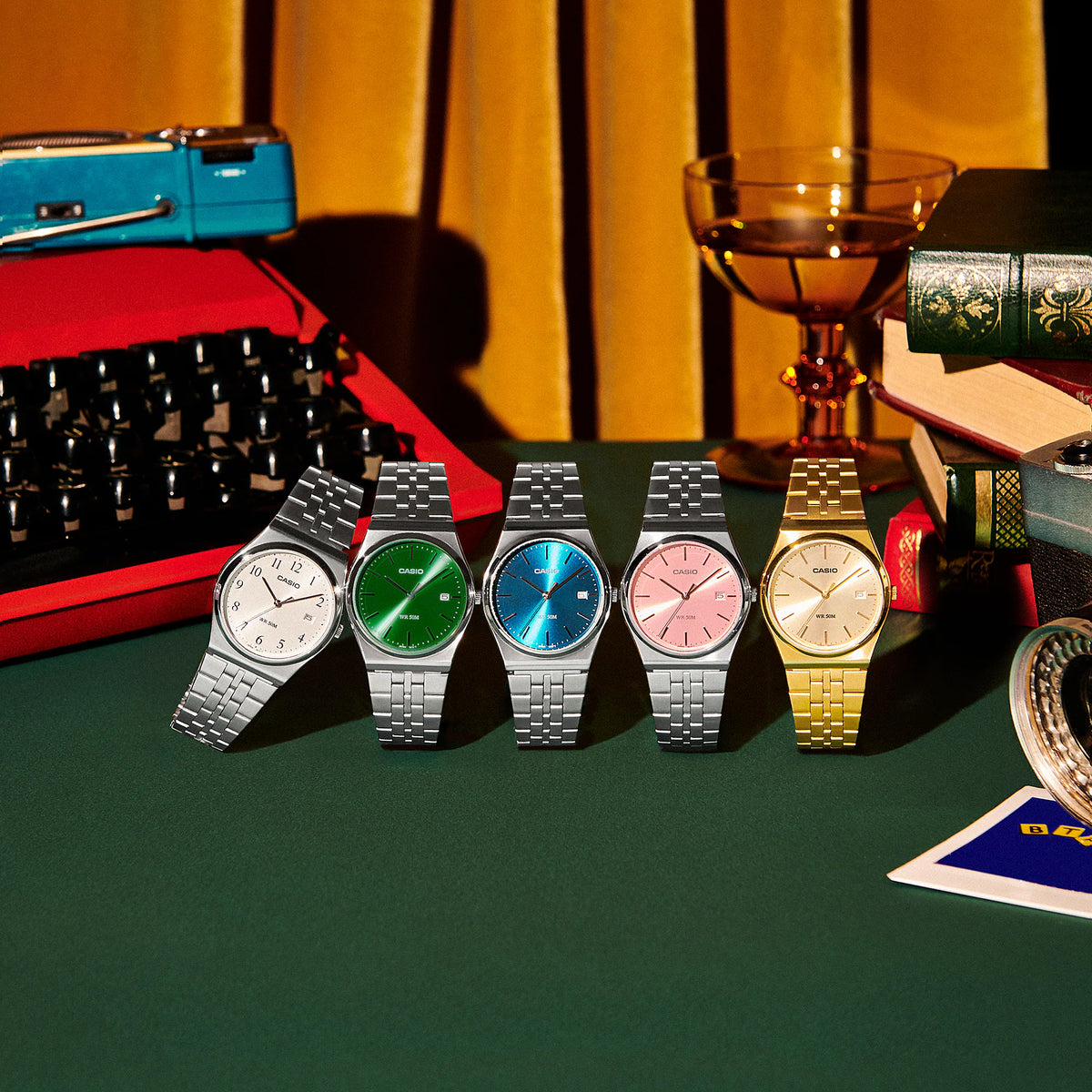 CASIO retro analog watch lineup featuring the MTPB145GC-9AV gold-tone model with stainless steel bracelet, displayed beside white, green, blue, and pink dial variants.