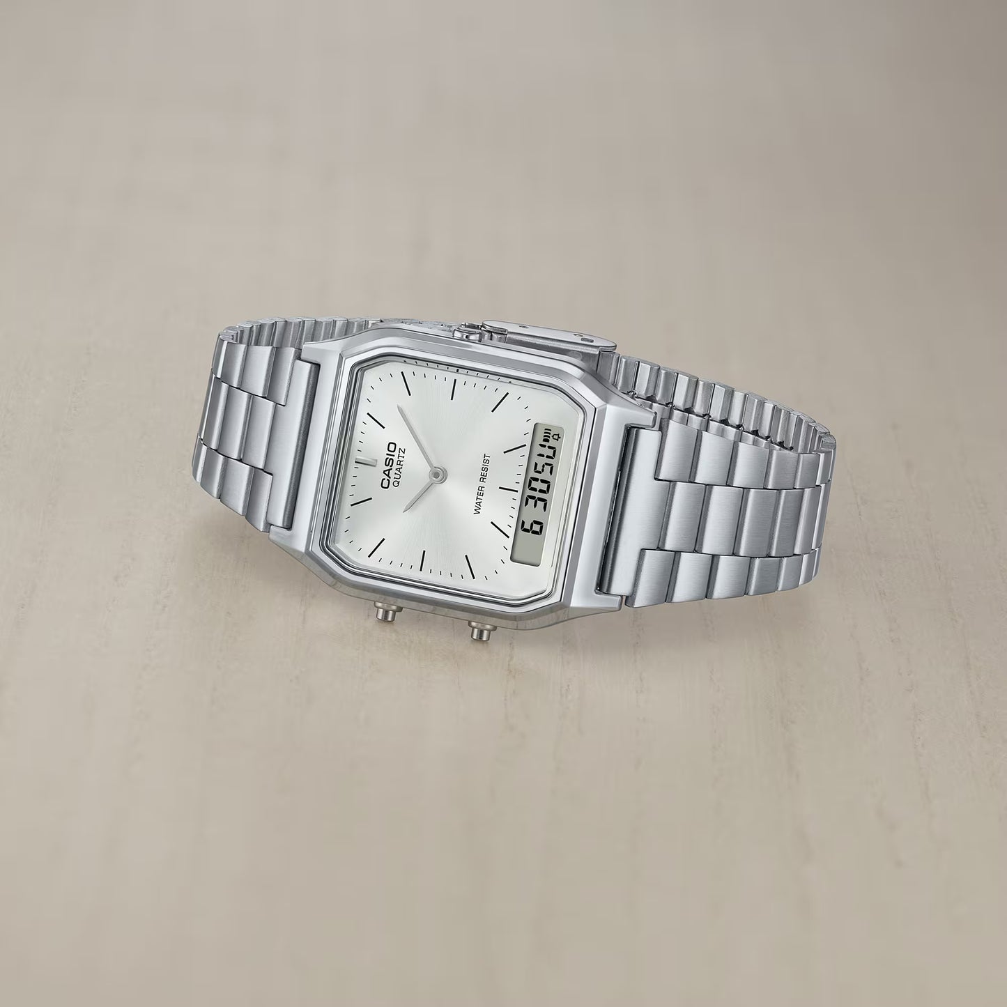 Silver Casio watch on a beige background