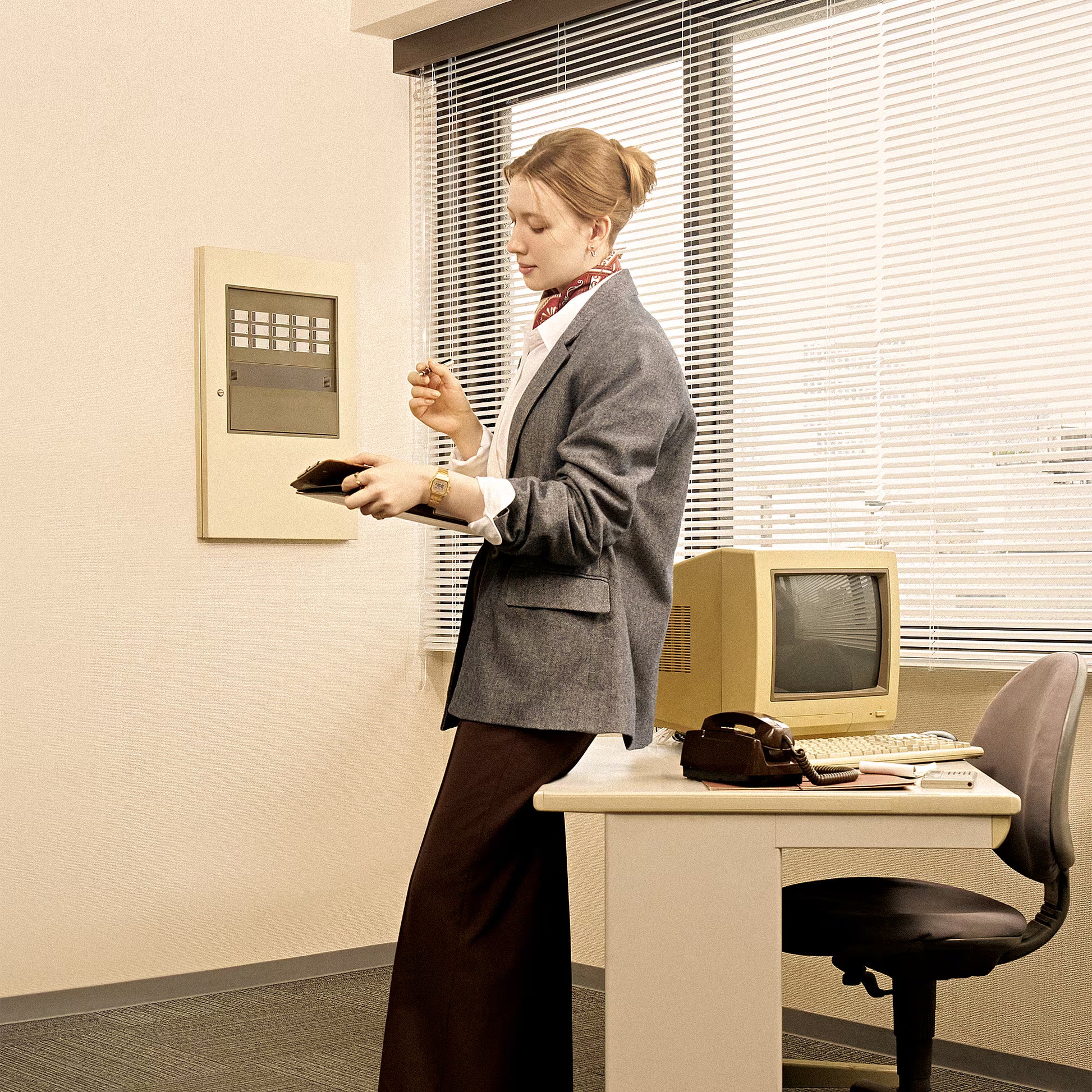 Woman in an office setting using a vintage computer.