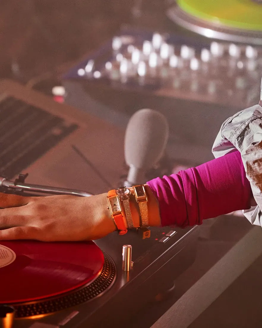 Person operating DJ equipment with a focus on hands and turntable, blurred background