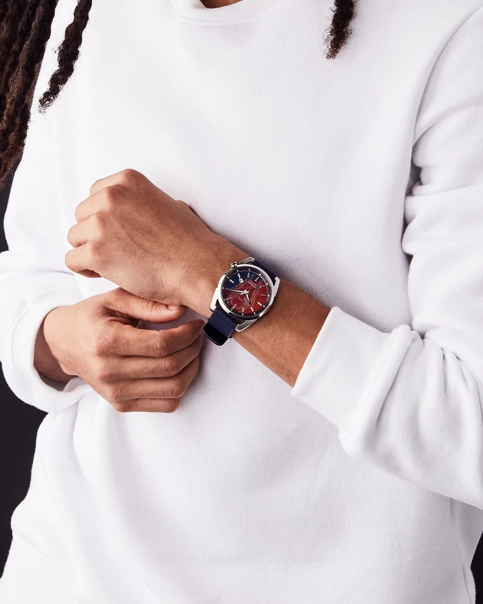 Lifestyle image of the Citizen Spider-Man AW1680-03W worn with a white sweatshirt, showing the red Spider-Man dial, blue leather strap, silver-tone case, and everyday Marvel style.