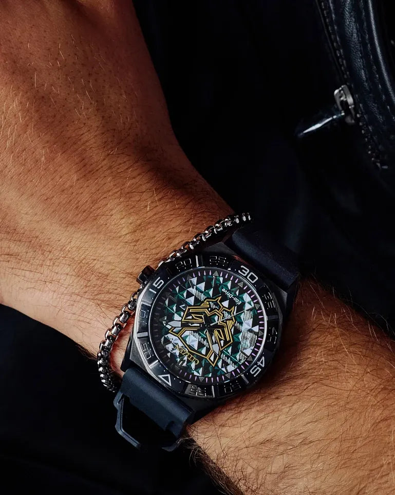 Citizen Black Panther 60th Anniversary AW1858-03W Eco-Drive watch with dimensional black dial, gold Black Panther mask logo, purple minute track, 42mm black IP stainless steel case, black silicone strap, sapphire crystal, and 100m water resistance.