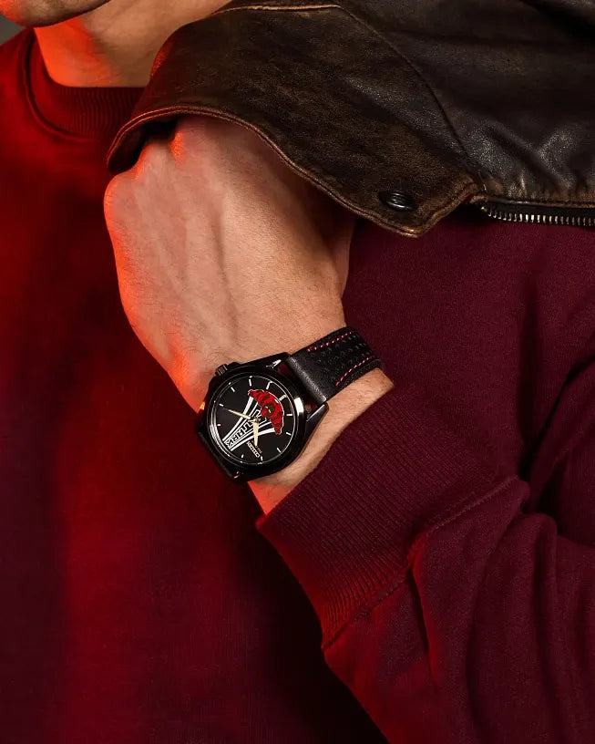 Lifestyle image of the Citizen Marvel Stark AW2095-41W worn on wrist with leather jacket styling, showing the black dial, Tony Stark artwork, and perforated black strap
