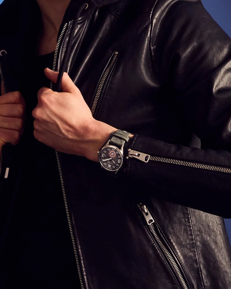 Citizen Captain America Forever BV1140-00W worn with a black leather jacket, highlighting the military-style dial, silver-tone case, and CORDURA nylon cuff strap.