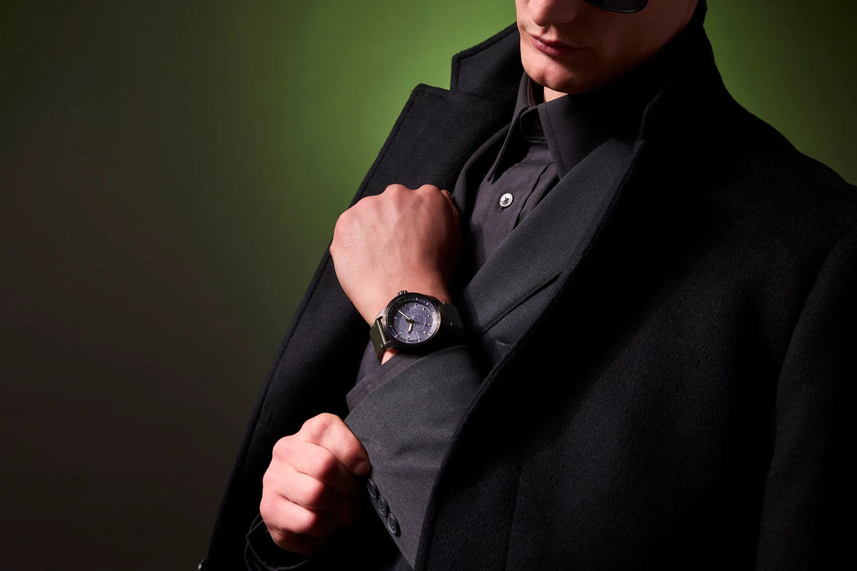 Lifestyle image of Citizen Avengers Dr. Doom AW5027-44W worn with a black outfit, featuring a gray Doctor Doom-inspired dial and green leather strap.