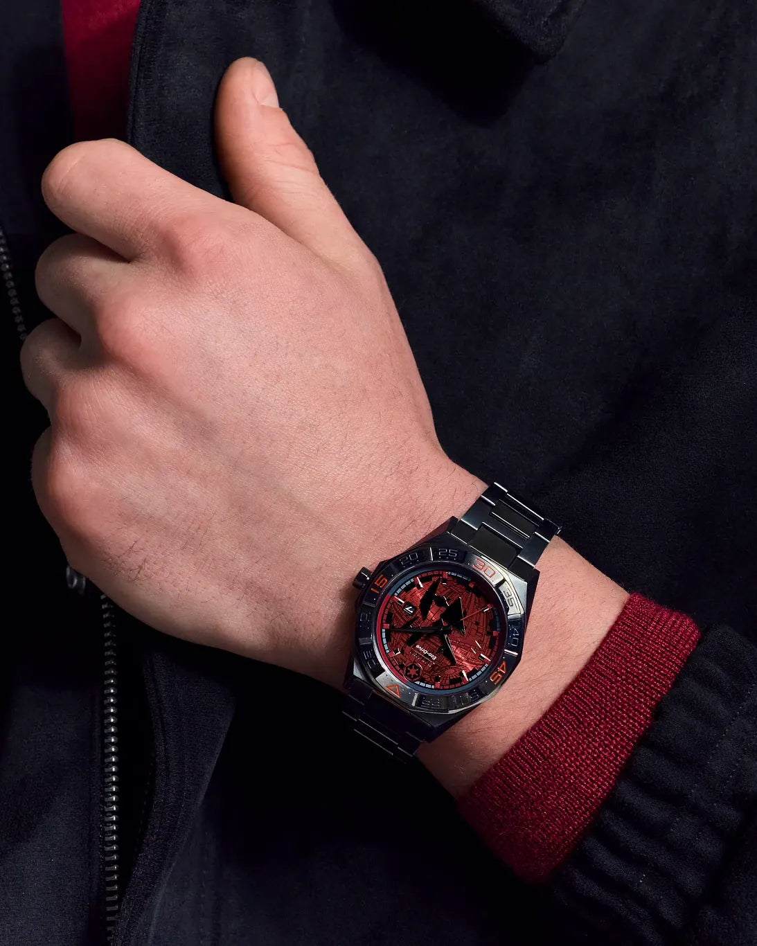 Close-up lifestyle image of the Citizen Star Wars Imperial Battle AW1857-57W on wrist, showing the red Death Star and TIE Fighter dial, Galactic Empire crest, gray ion-plated case, and stainless steel bracelet.