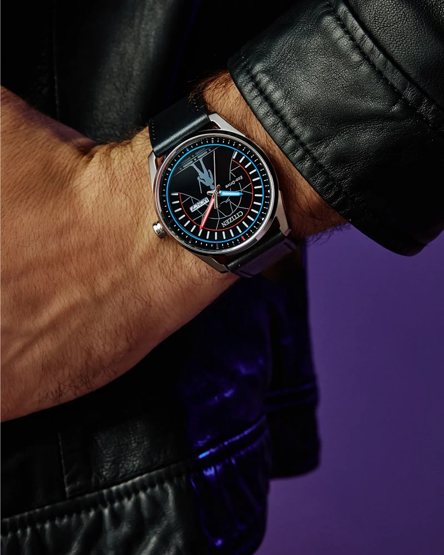 Close-up of a person wearing a black leather watch with a detailed face against a dark background