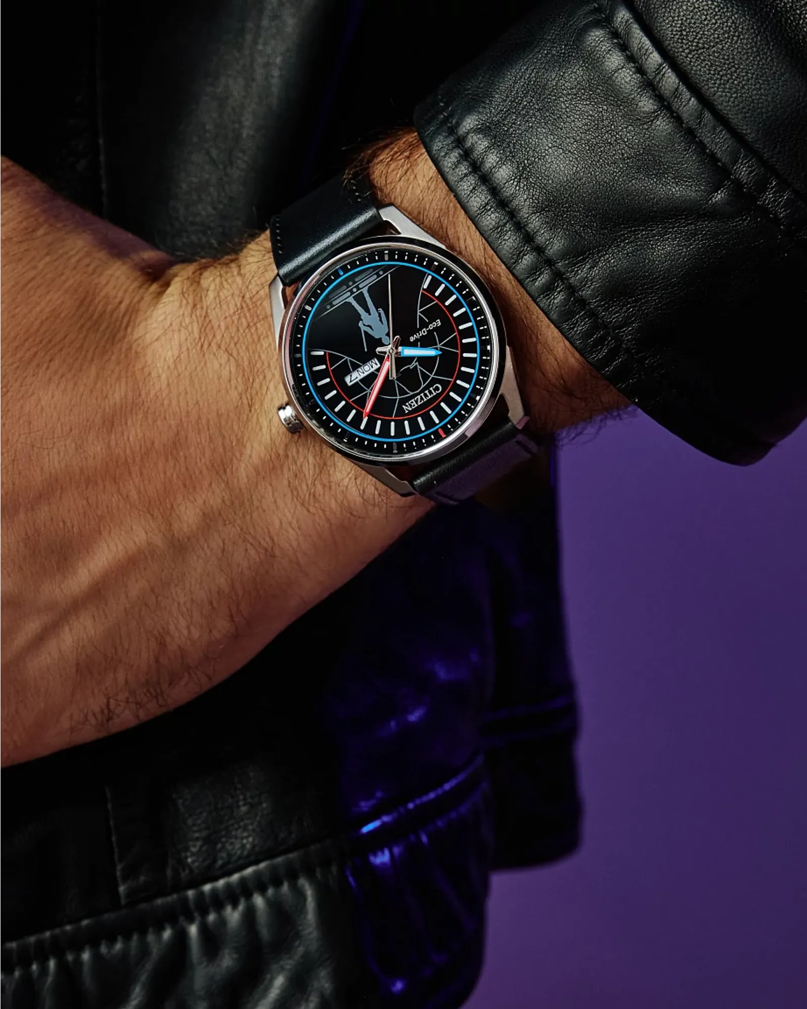Close-up of a person wearing a black leather watch with a detailed face against a dark background