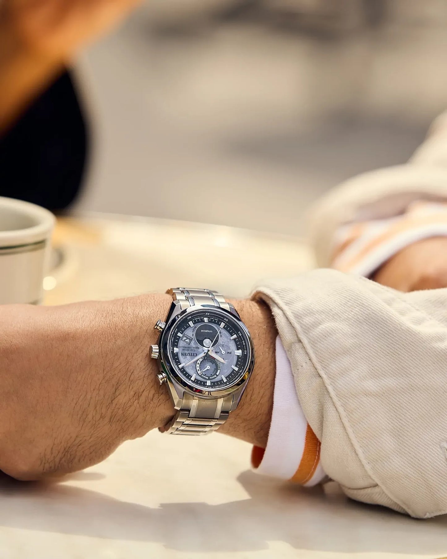 Person wearing a silver watch with a blurred background