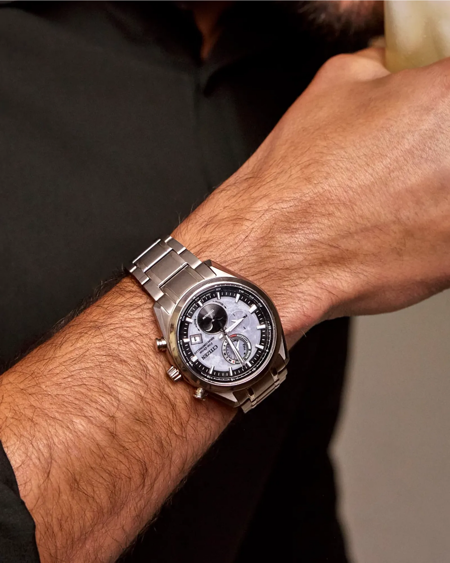 Silver wristwatch on a person's wrist with a blurred background