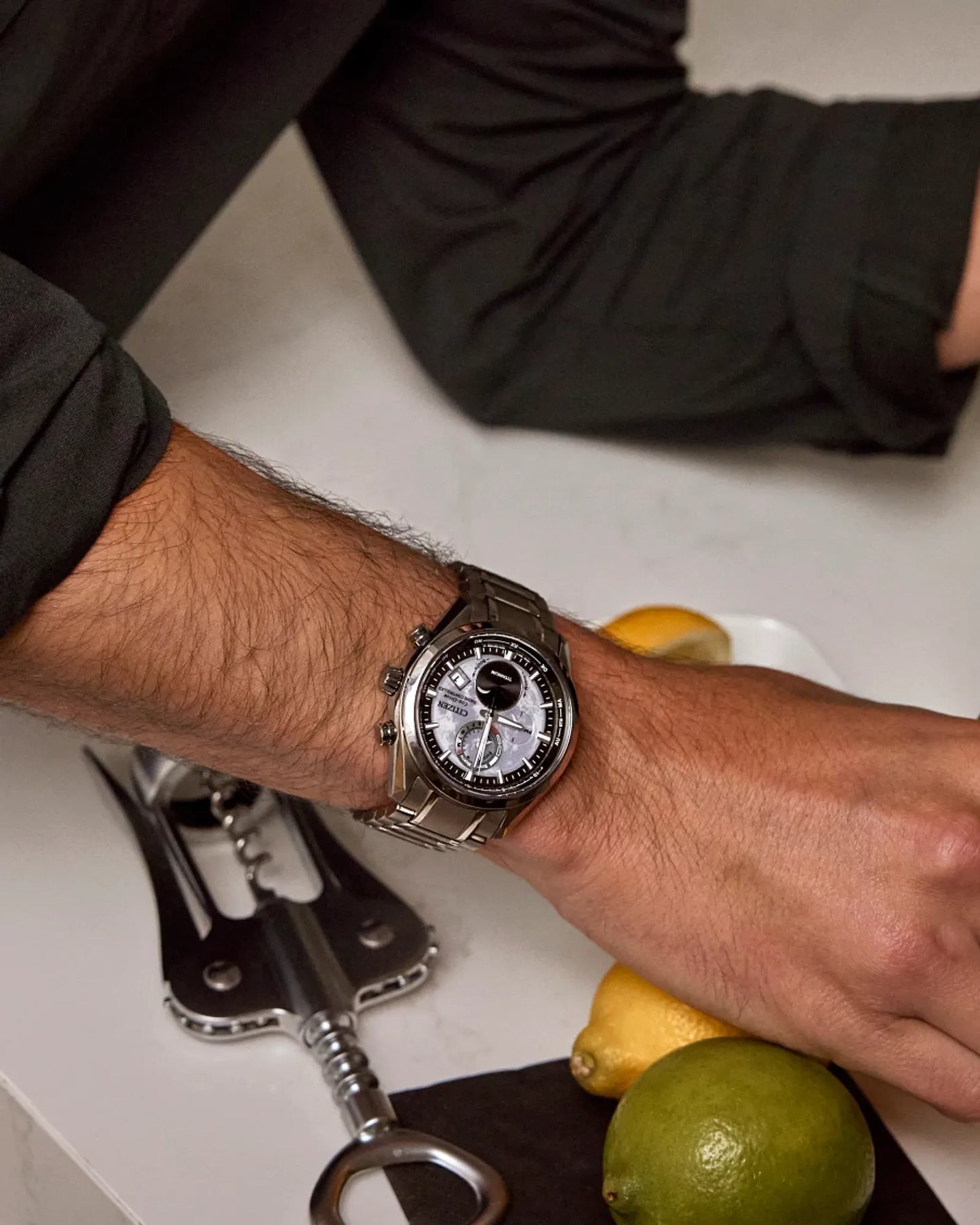 Person wearing a watch with a kitchen setting in the background