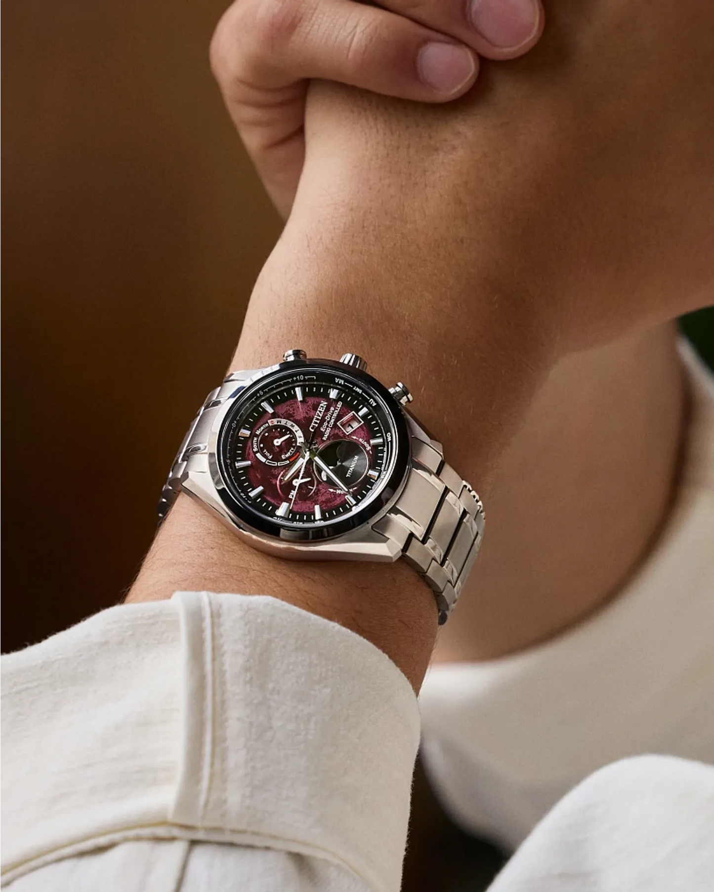 Close-up of a wrist wearing a silver watch with a dark face.
