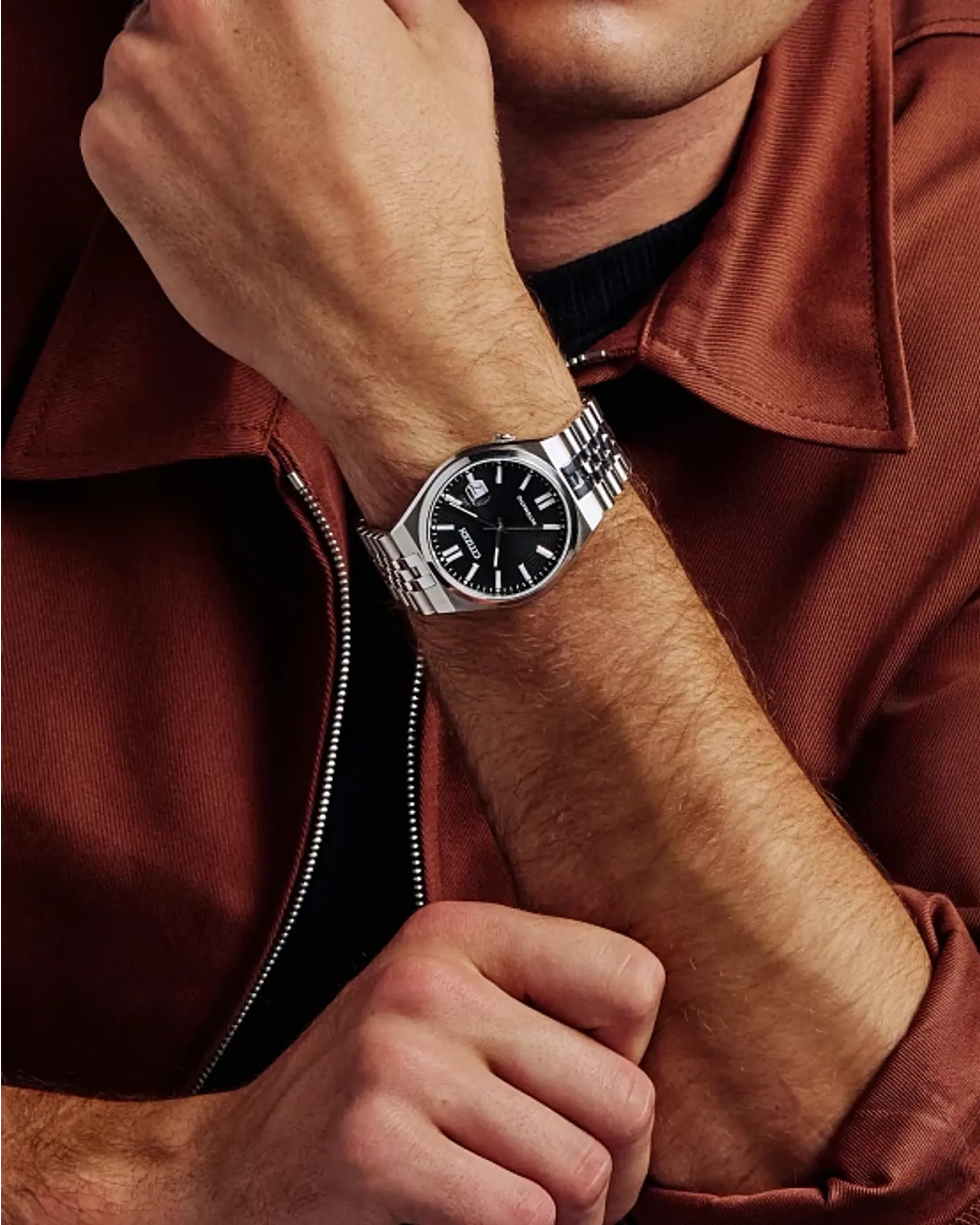 Person wearing a watch with a red jacket