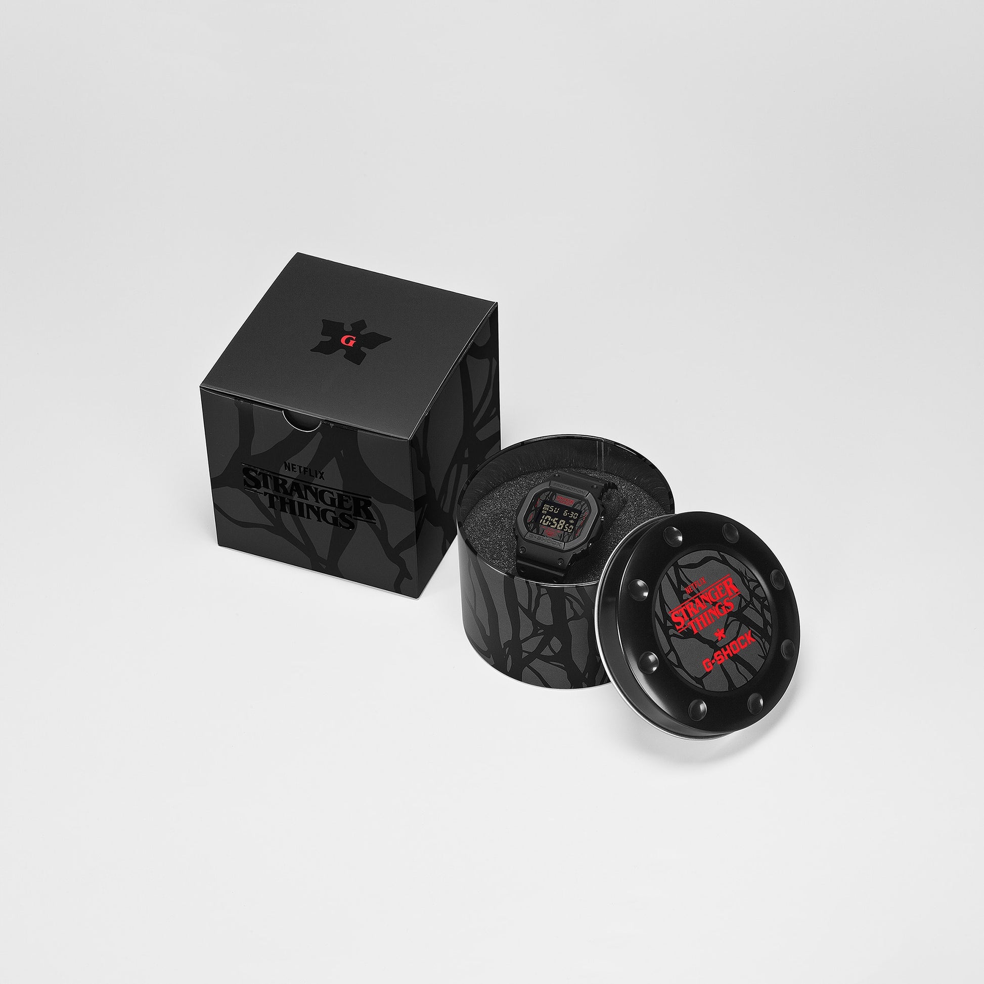 G-SHOCK DW5600STT-1 Stranger Things collaboration featuring vine-pattern dial inspired by Vecna, upside-down ‘A’ detail, red LED backlight, ‘011’ band loop tribute, bio-based black resin case and band, and special Demogorgon-themed packaging.”