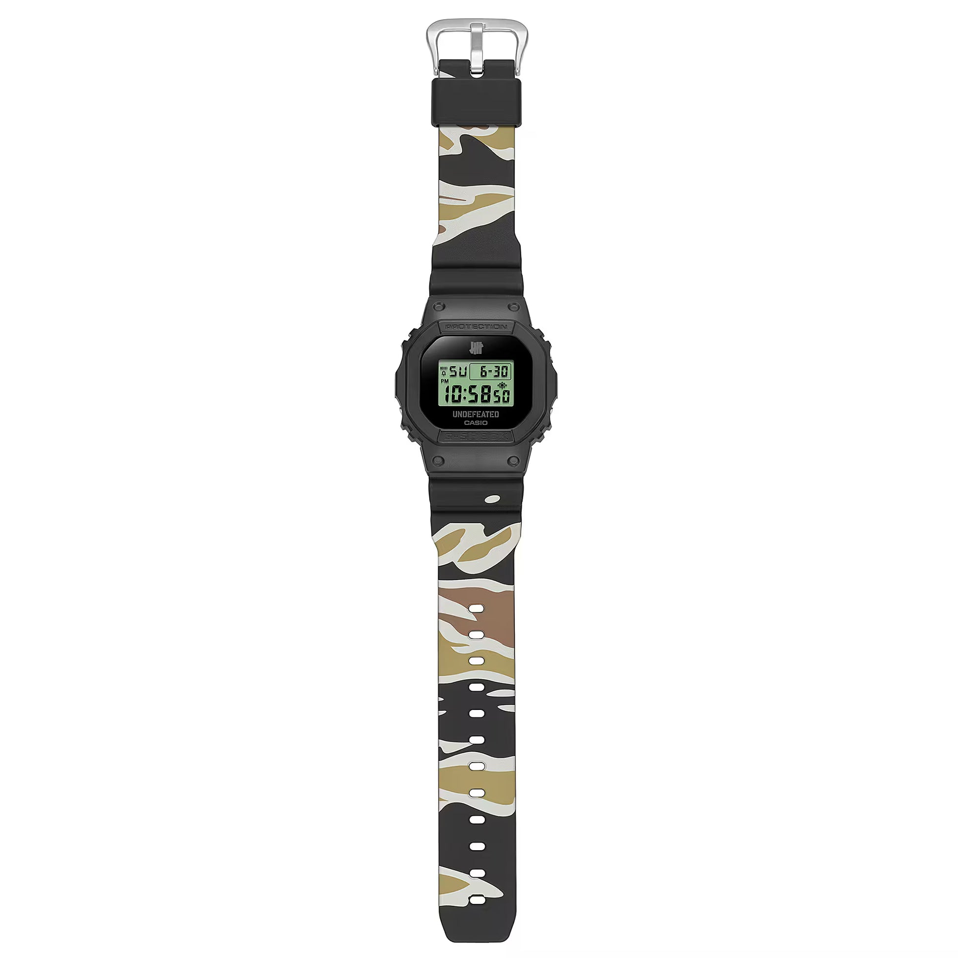 Casio G-SHOCK DWE5600UD-1 UNDEFEATED collaboration model with matte black Carbon Core Guard case, semi-translucent resin band featuring UNDEFEATED logo, green LCD display, engraved caseback, and special packaging. Includes two interchangeable camouflage straps (tiger camo, storm camo). Features shock resistance, mineral glass, 200m water resistance, LED Super Illuminator backlight, stopwatch, countdown timer, alarms, flash alert, auto-calendar, and ±15 sec/month accuracy. Case size 48.9 × 43.8 × 13.7 mm, we