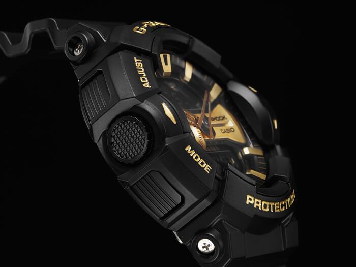 Close-up of a black and gold G-Shock watch with visible branding on a dark background