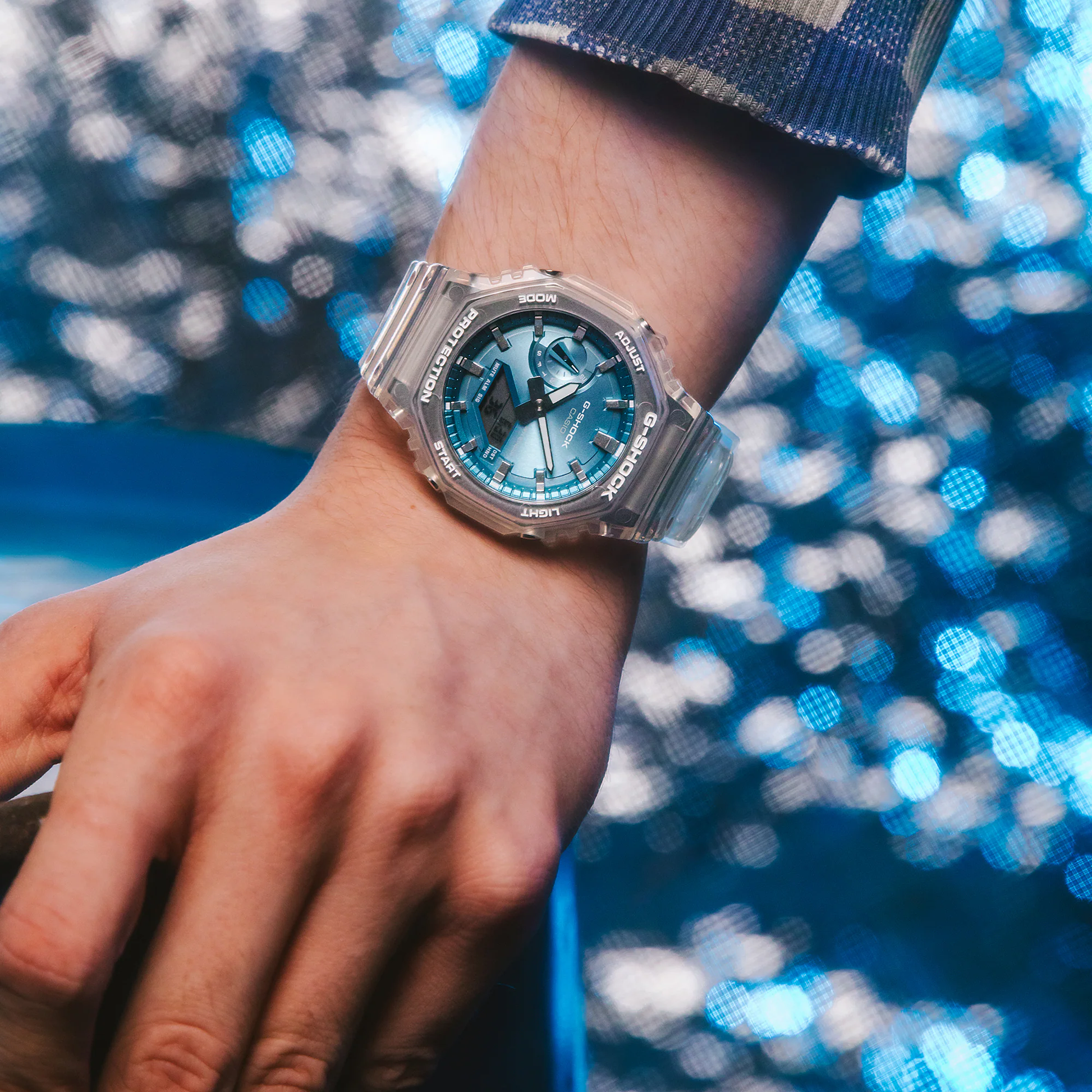 Casio G-Shock GA2100BM-7A2 watch with translucent resin case and band, metallic sky-blue dial, octagonal bezel, and Carbon Core Guard construction
